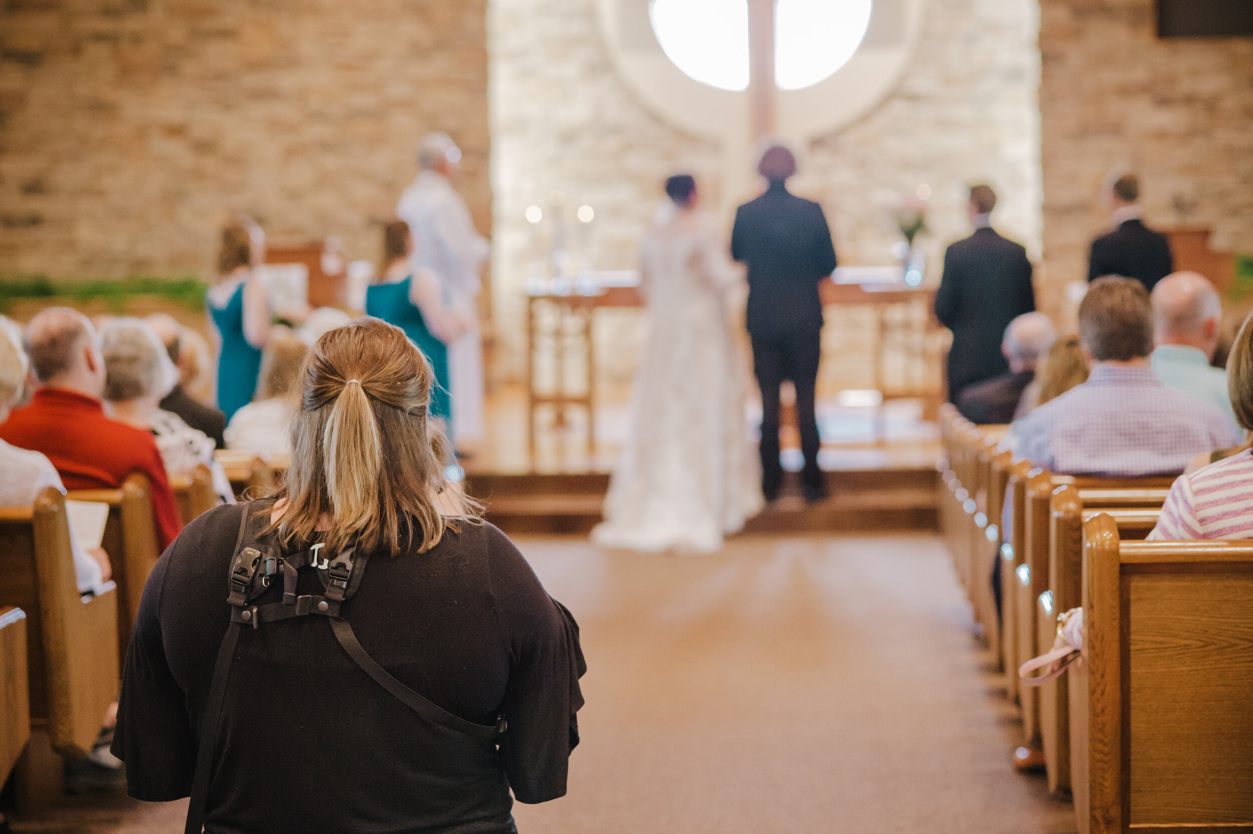 Photographer capturing indoor wedding ceremony in a church