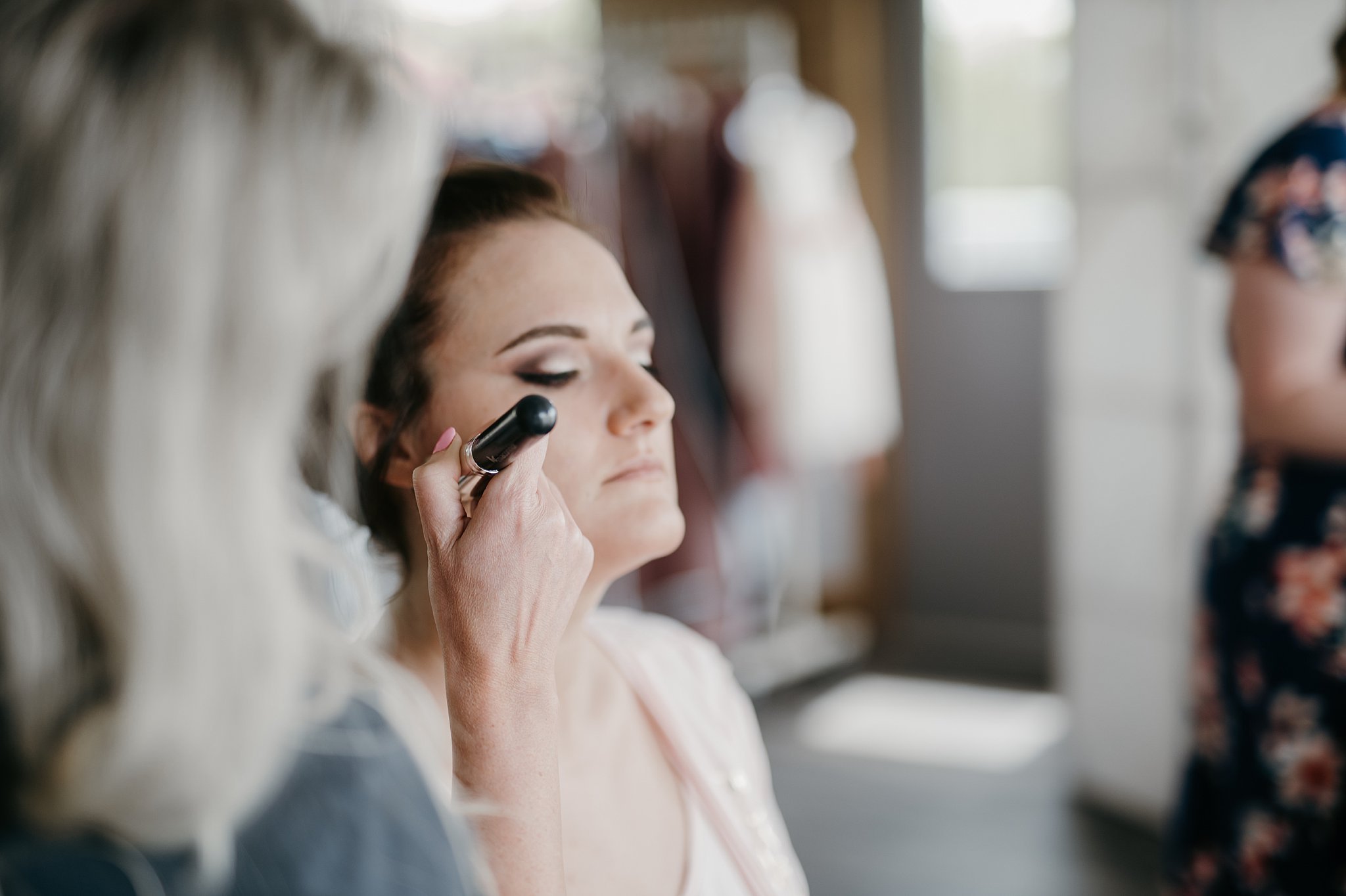 Minnesota wedding photographer takes photo of bride getting make up done