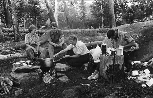 Patsy English, David Brower, Virginia Adams and Jules Eichorn cooking a meal in their camp, 1930's. Photograph by Ansel Adams.