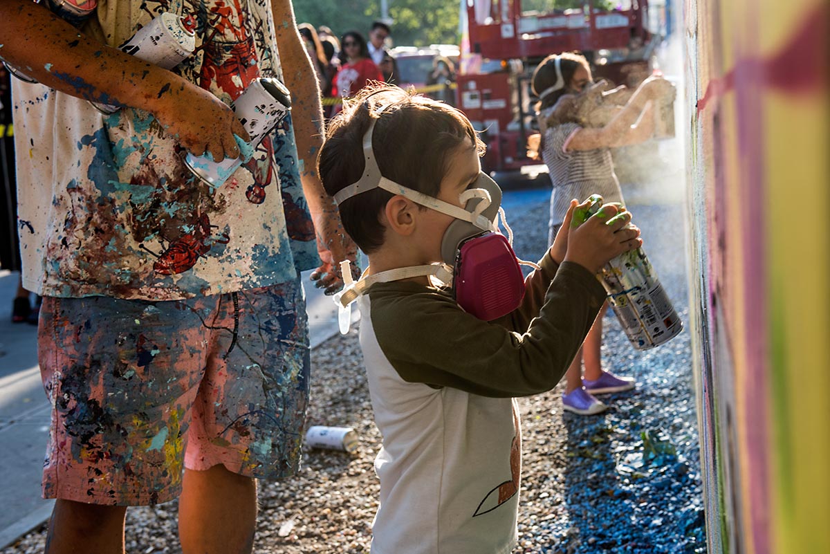  Young child painting alongside artist David Choe at the Bowery graffiti wall in New York. Photo by Martha Cooper. 