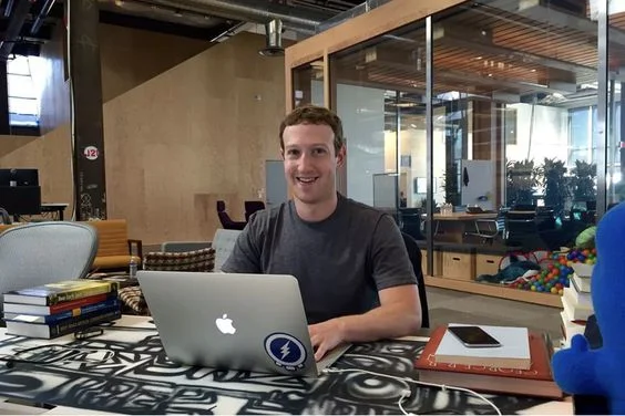 Mark Zuckerberg at Facebook with his desk painted by artist David Choe 