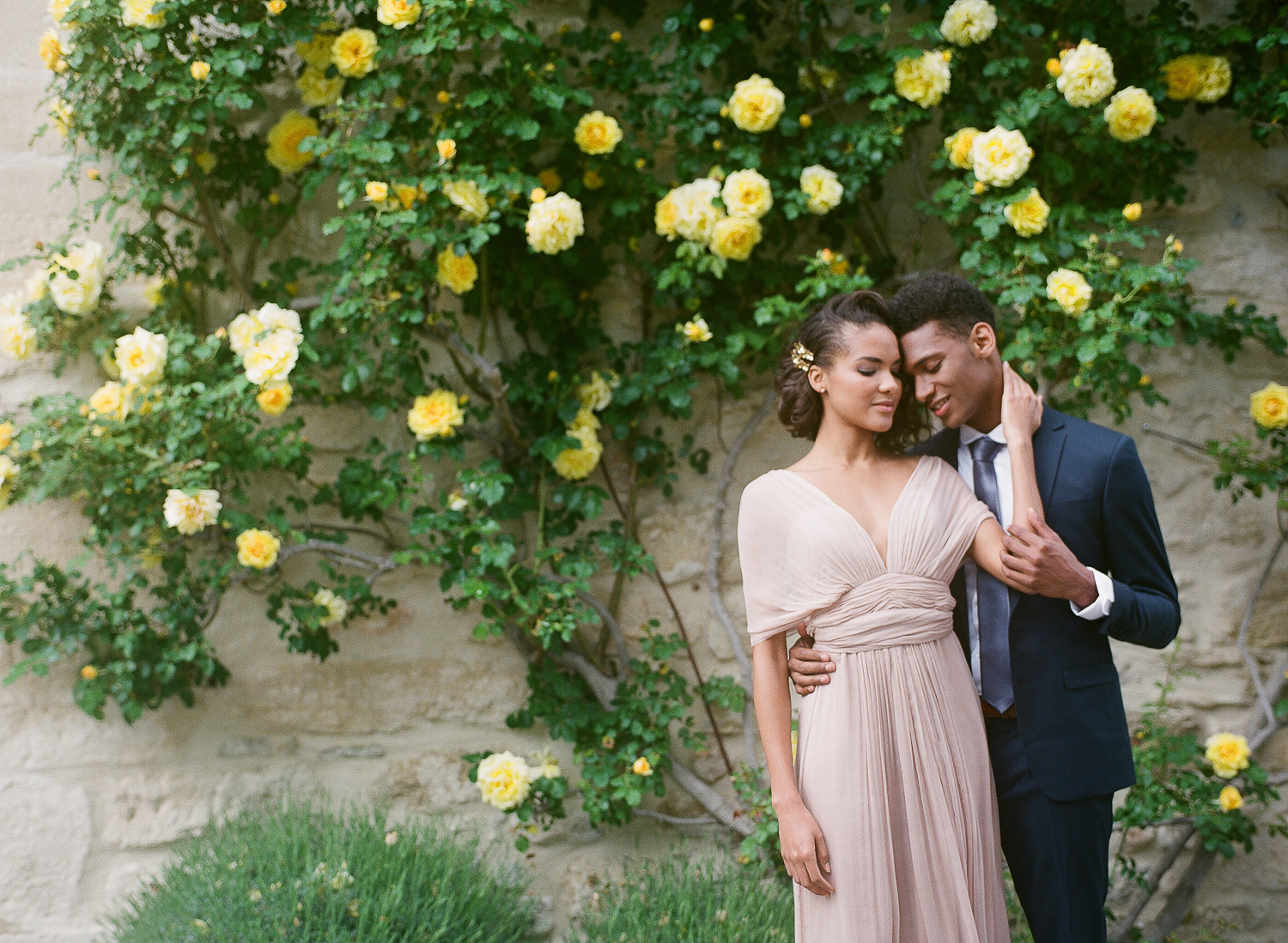 Beautiful black bride and groom in front of roses
