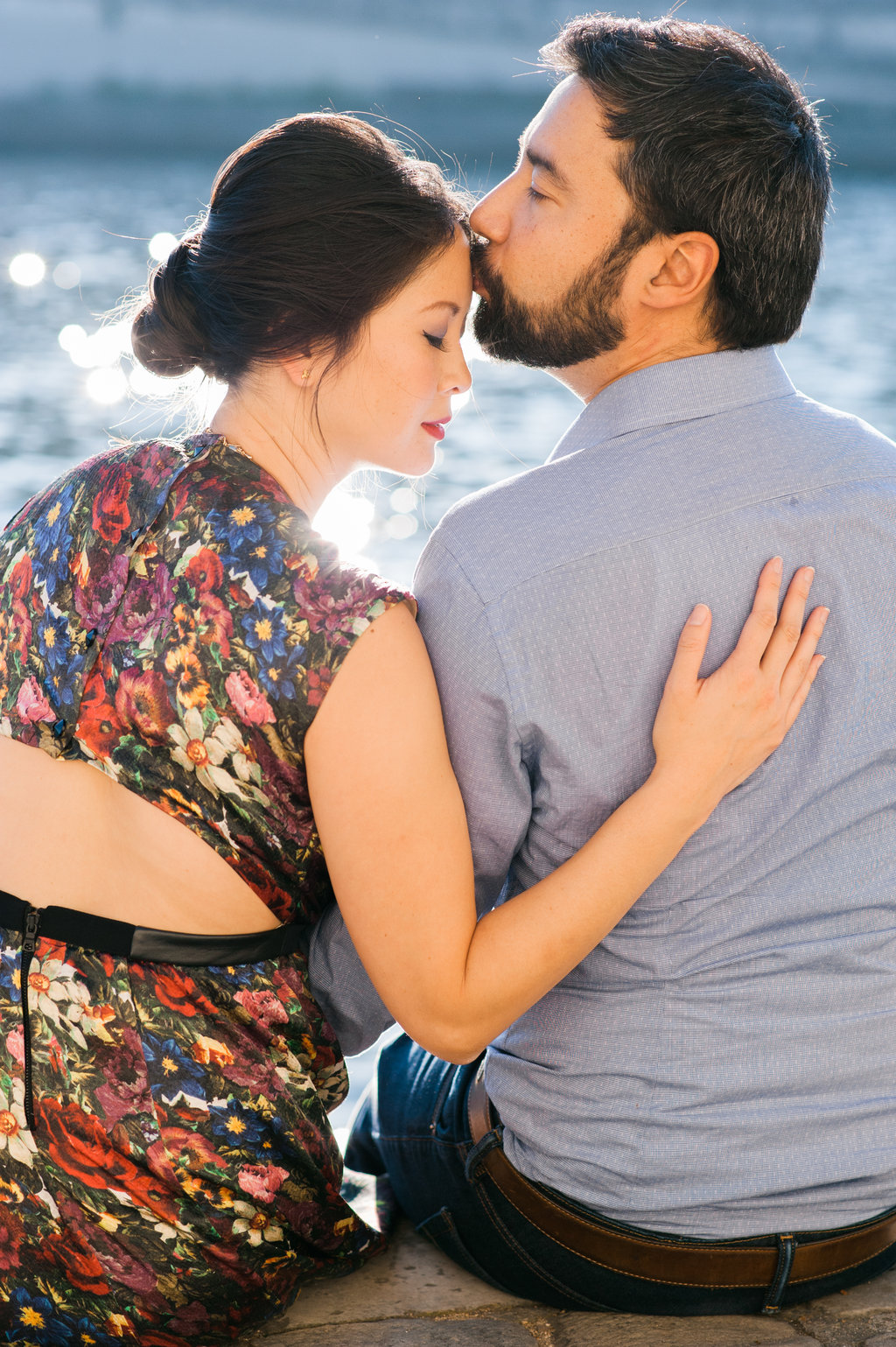 Gentle kiss along river le Seine bride wearing floral bear back dress