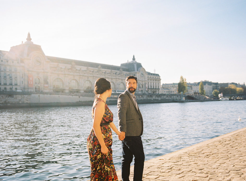 Couple holding hands by river Seine Paris
