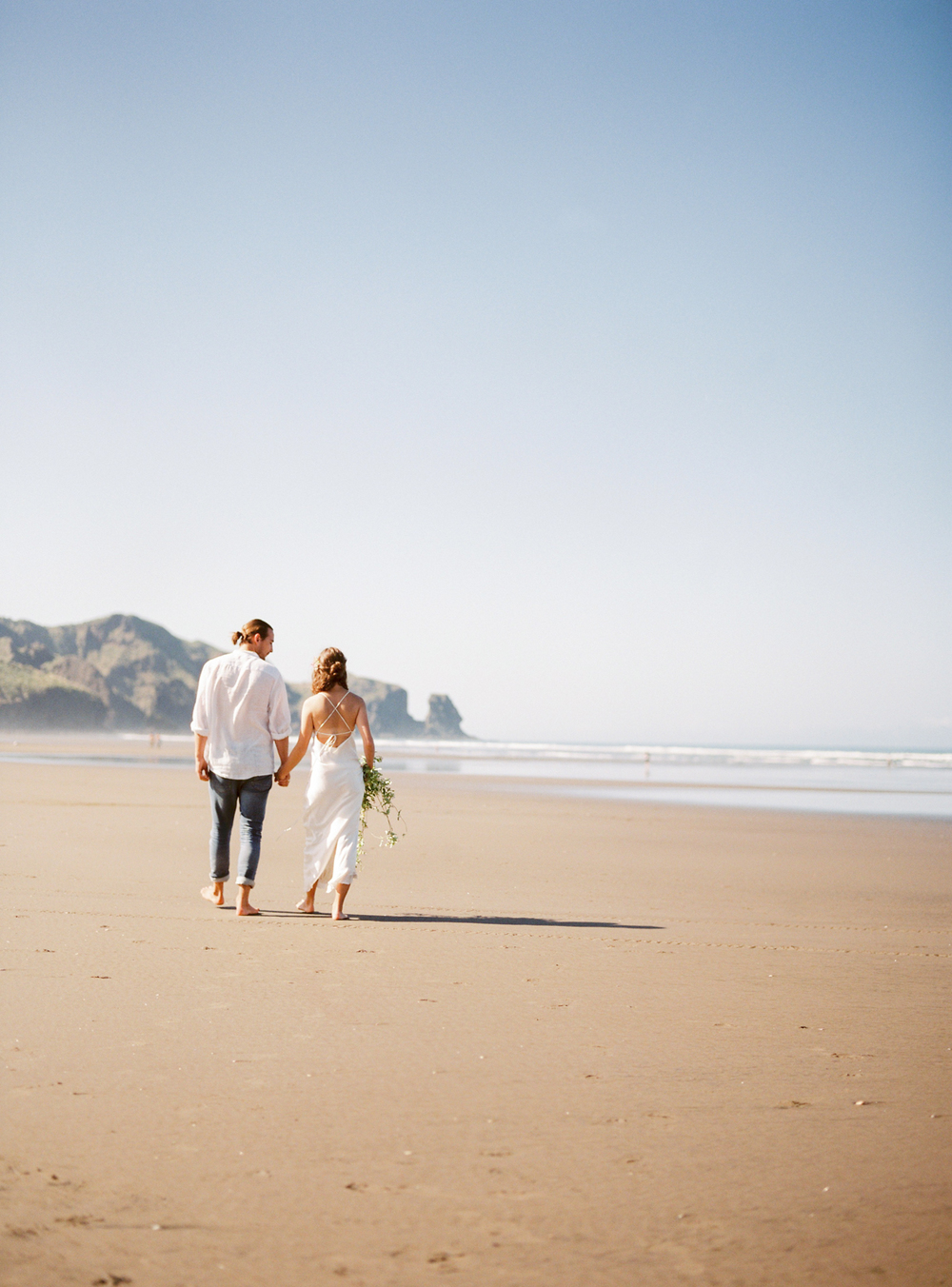 Couple walking down the beach in New Zealand elopement