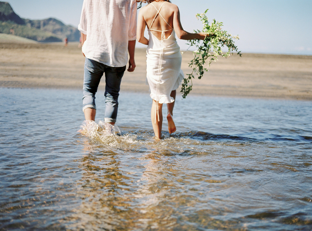 Couple walking in the water for wedding in New Zealand