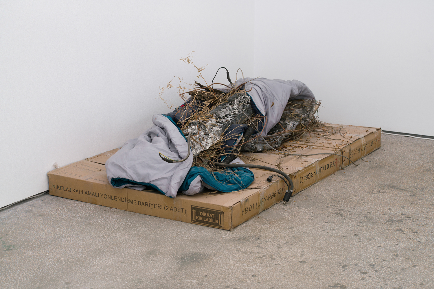 Nomadic condition 2018 Nicolas Lamas Sleeping bag, radiator, cables, straw, ashes, cardboard, potatoes; variable dimensions