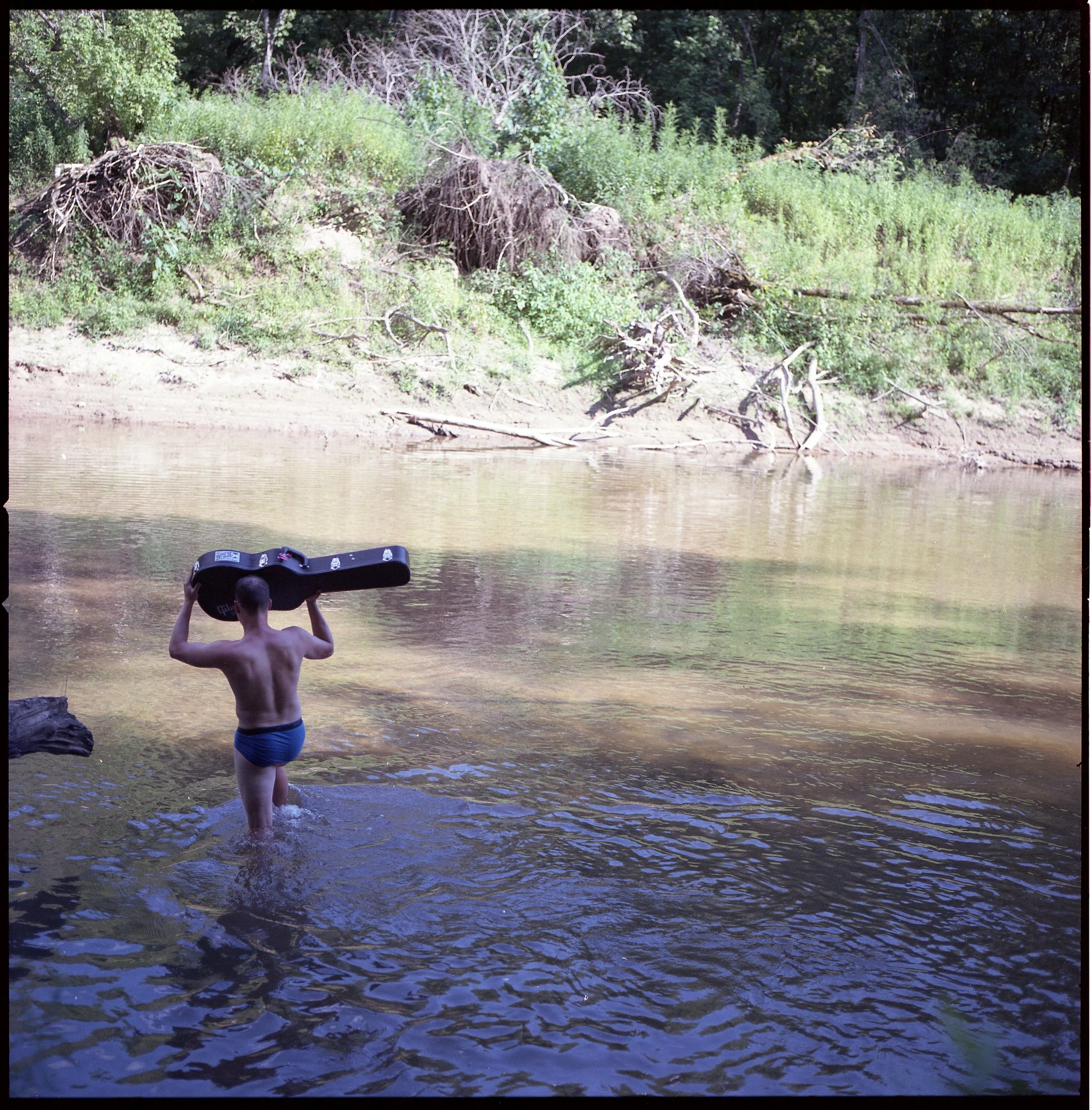 Drew fording the river to give Matt his Gibson.
