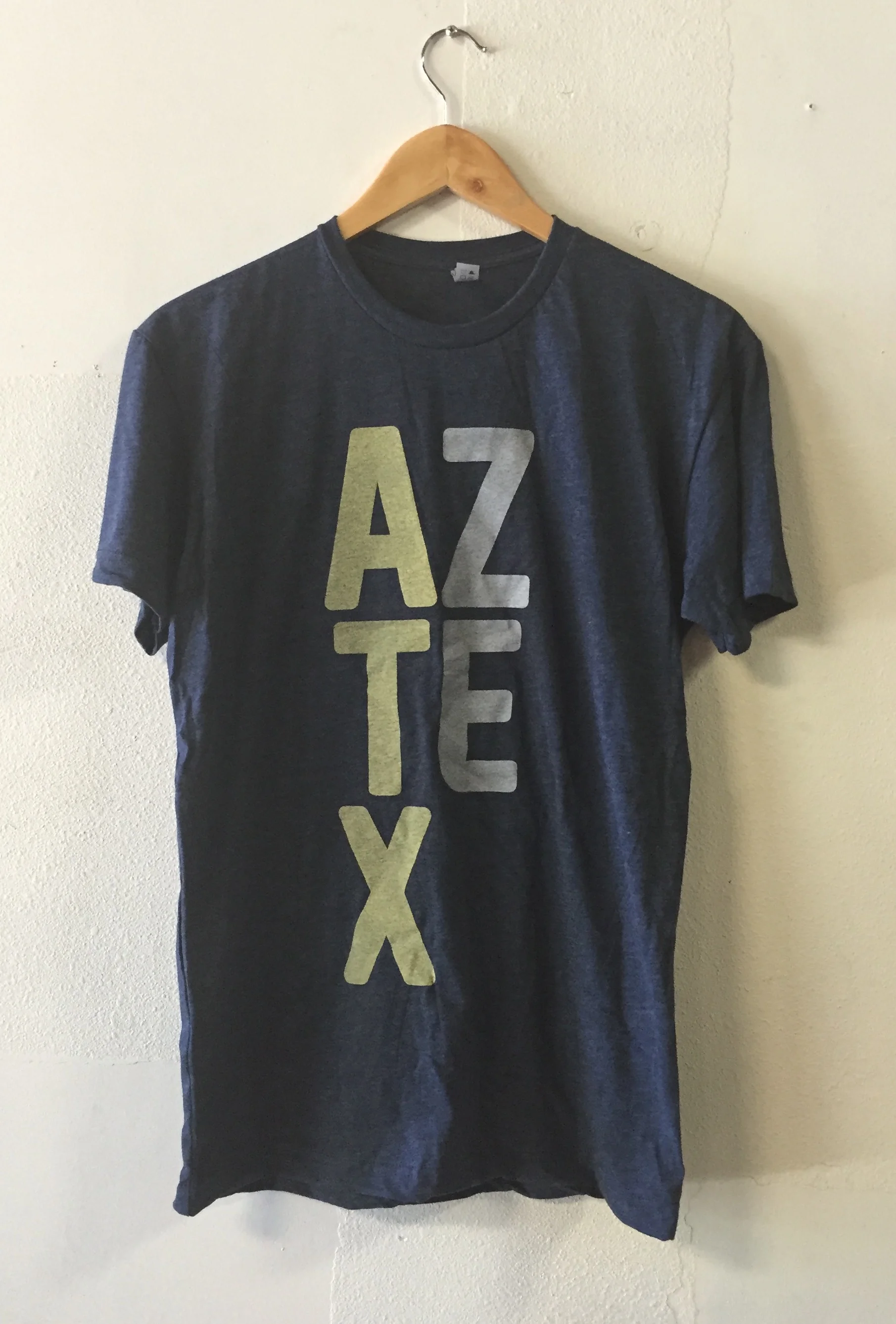 Custom screen printed merch shirts for the Austin Aztex featuring an ATX graphic produced in Austin, TX.