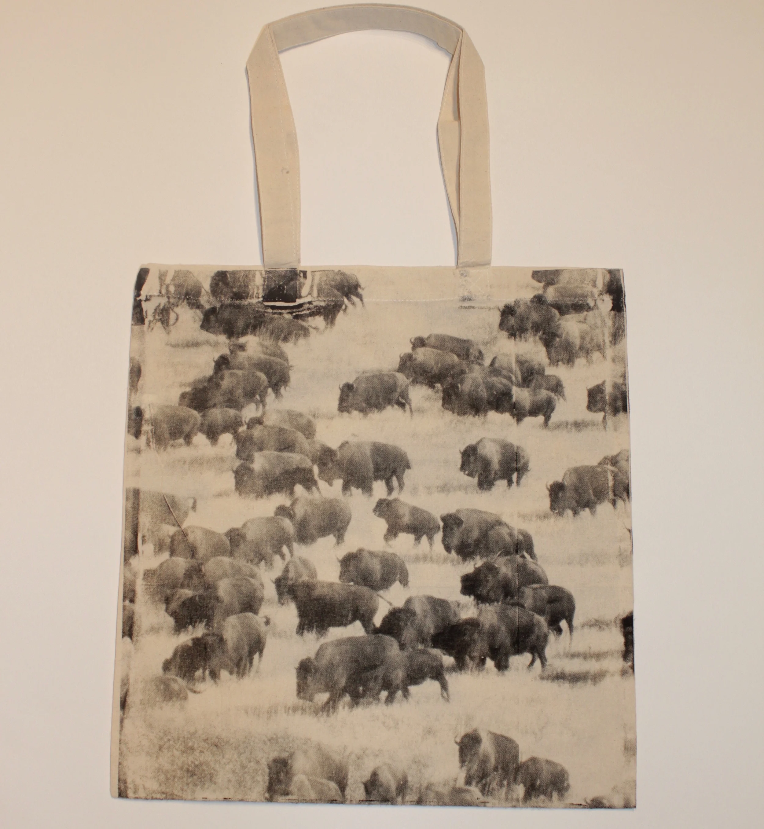 Tote bag displaying a black and white image of a buffalo herd.