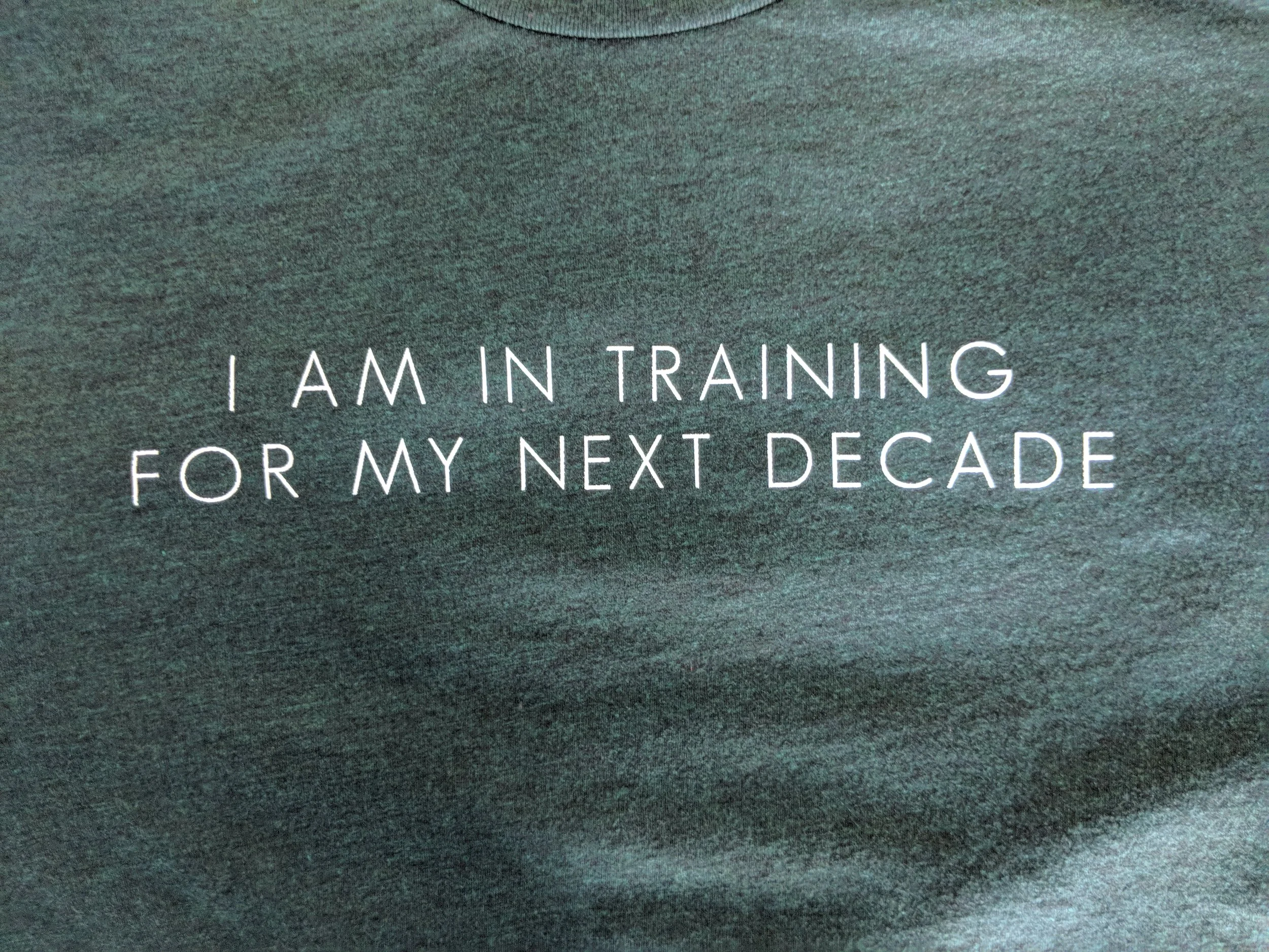 Custom water-based screen printing on a dark heather green athletic workout shirt.