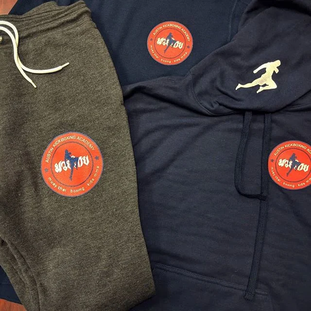 Custom screen printed athletic shorts and performance outerwear produced for Austin Kickboxing Academy fitness apparel.
