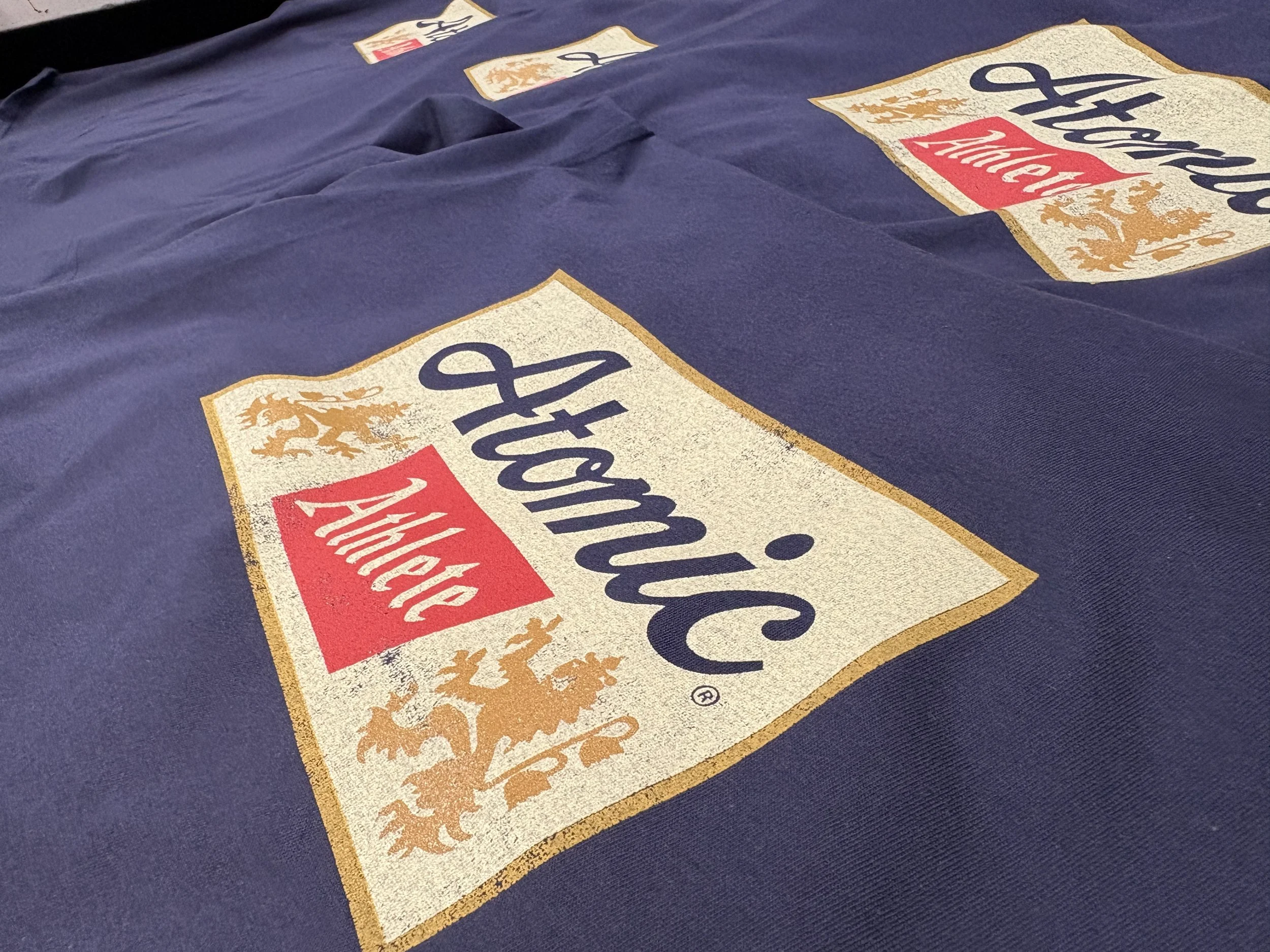 Custom screen printed moisture-wicking gym shirts produced for our long-term client Atomic Athlete in Austin, TX.