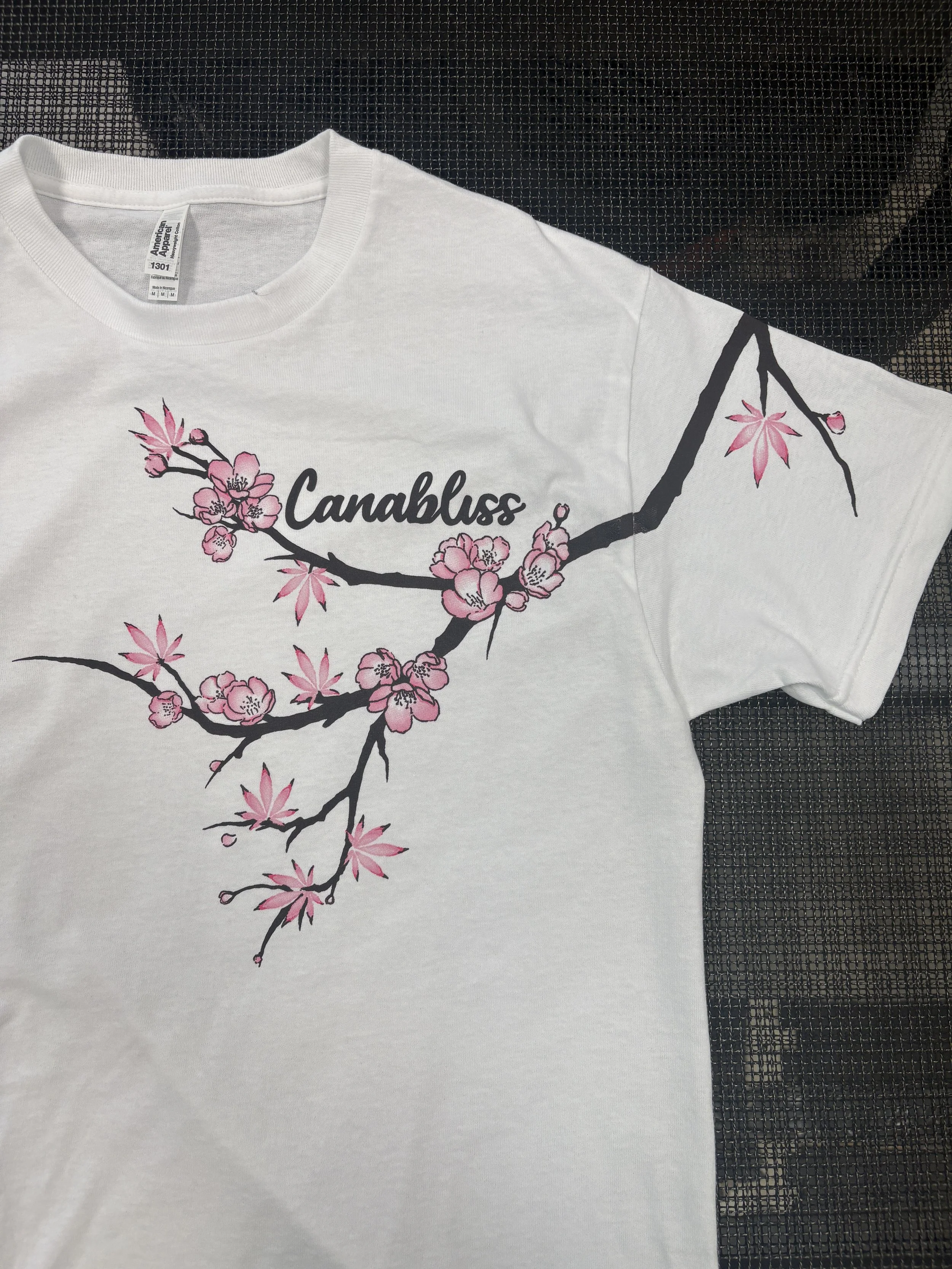 Retail-ready custom screen printing featuring cherry blossoms produced for the Cannabliss clothing brand.