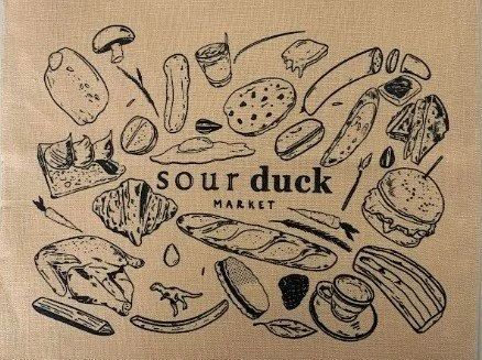Custom screen printed canvas drawstring tote bag for Sour Duck Market in Austin, Texas.