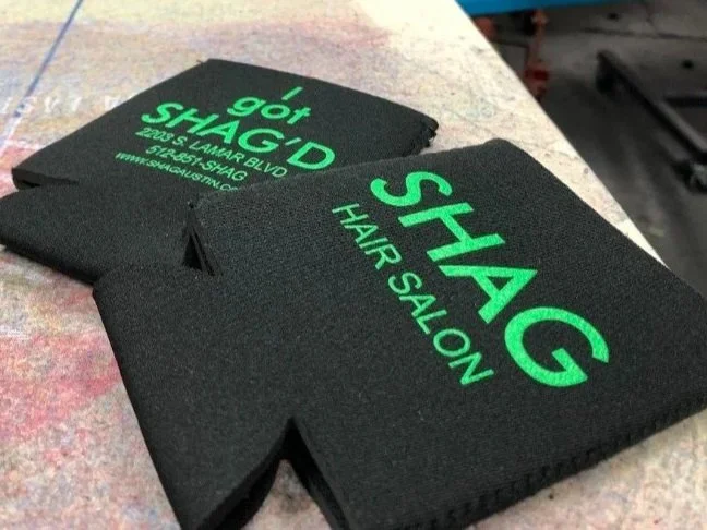 Custom screen printed promotional koozies produced for SHAG Hair Salon in Austin, TX.