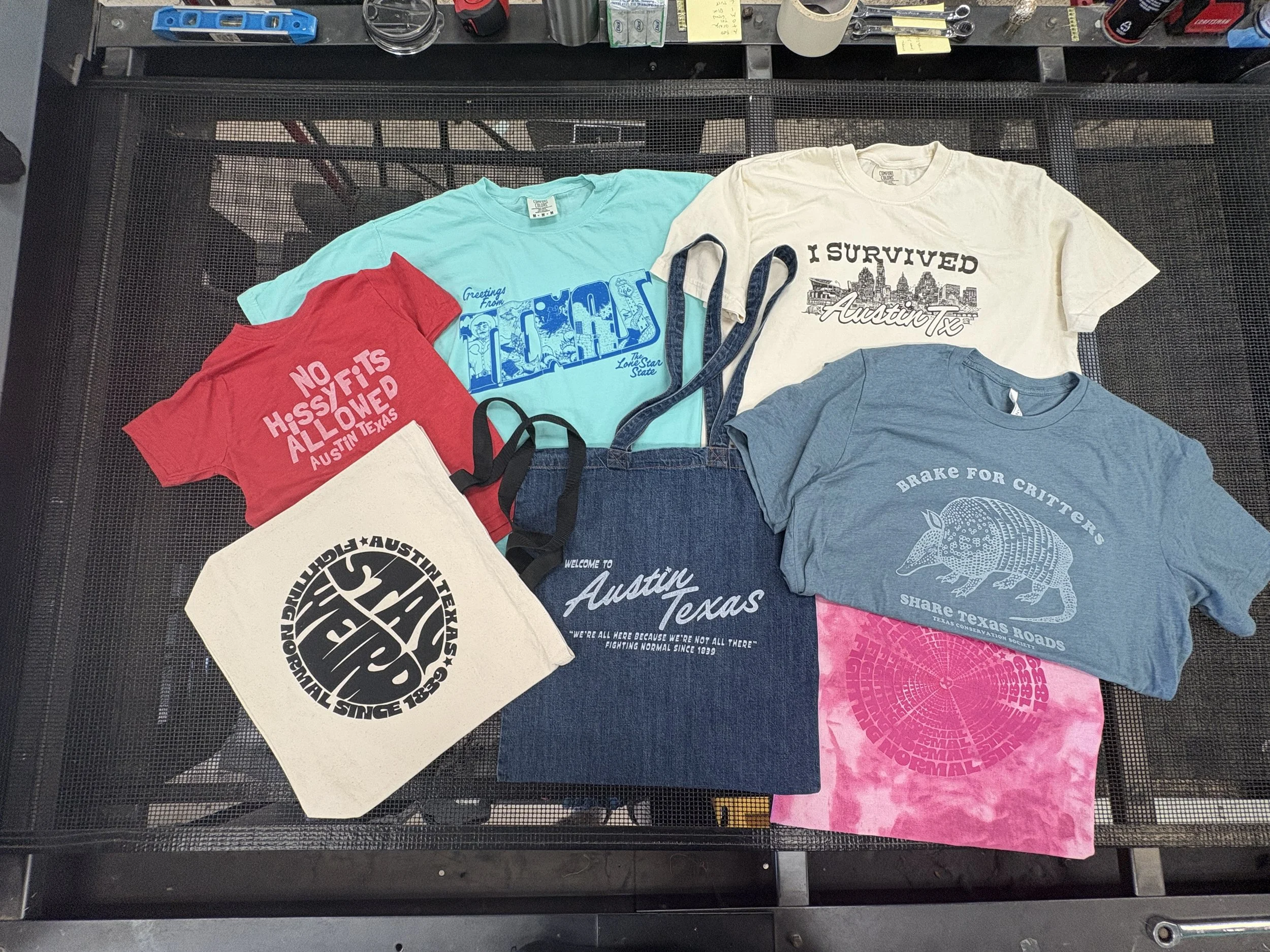 Custom screen printed denim tote bags and souvenir apparel featuring Austin Texas graphics.