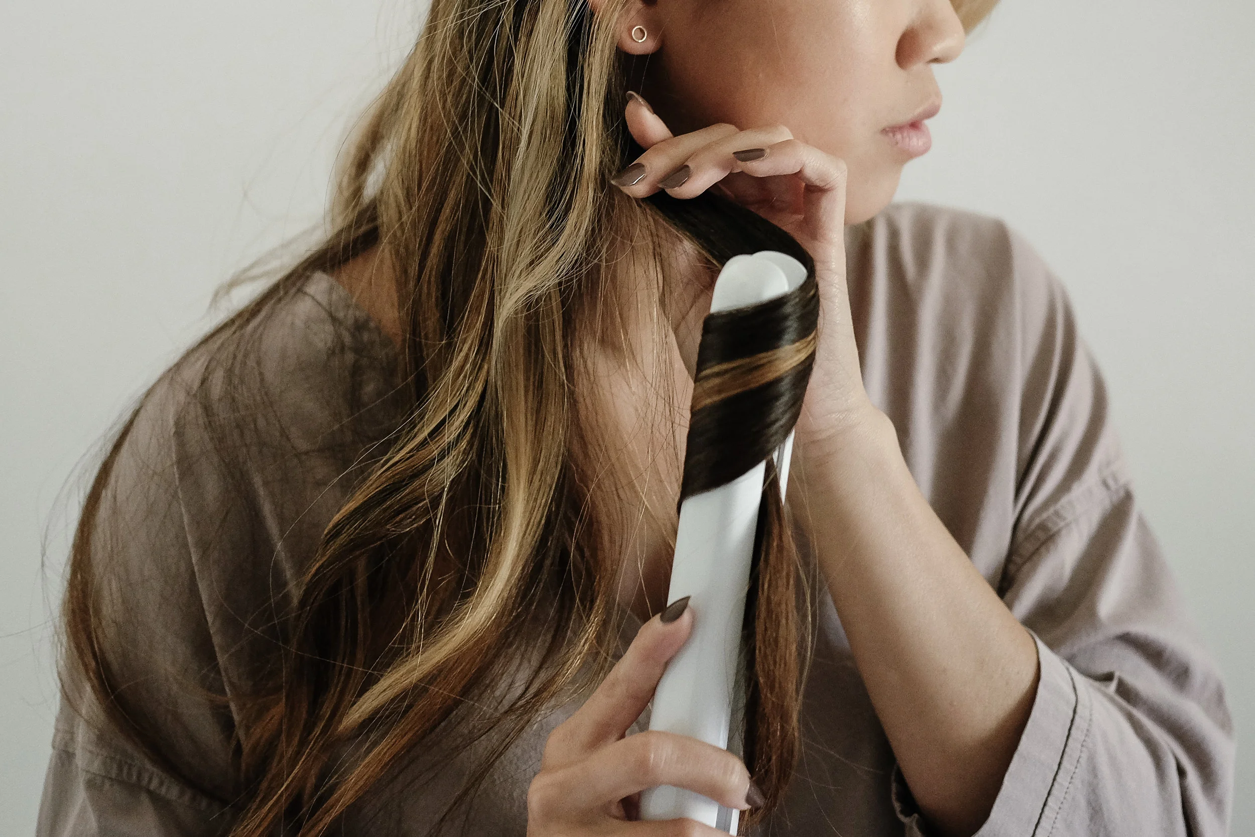Now its time to start curling! I like to start a few inches from my roots, and rotate the straightener which will wrap the hair around once.&nbsp;