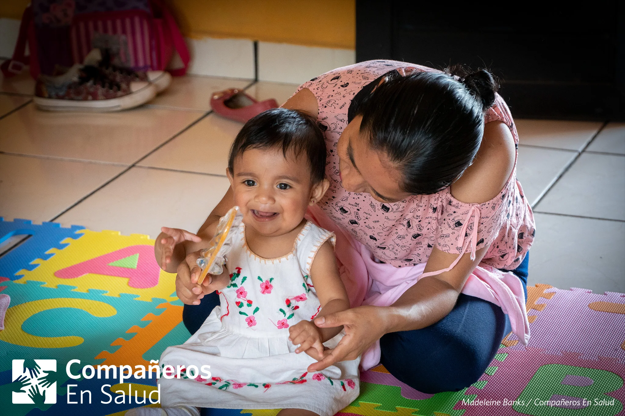 Durante un curso de desarrollo infantil y estimulación temprana en Jaltenango de la Paz, la mamá Verónica Ramírez Torres ayuda a su hija Regina a tocar un pequeño instrumento musical.