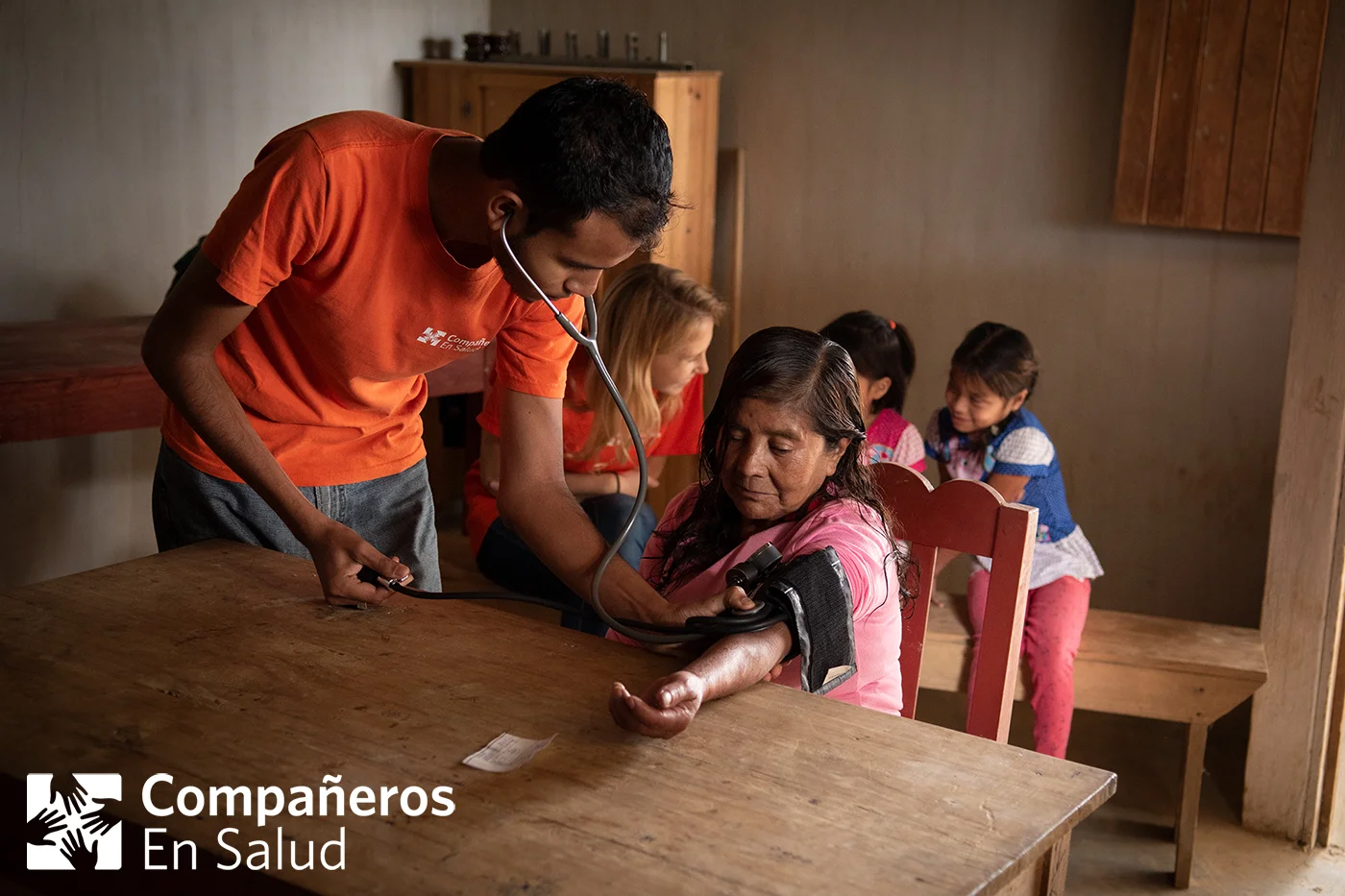 Las personas que hayan presentado ciertos riesgos, acuden después a un lugar público en la comunidad para someterse a pruebas confirmatorias. Luego, si sus resultados lo indican, nuestro equipo les remite a nuestro médico de la clínica comunitaria. Foto: El Dr. Rizieri Puerto, médico de la clínica de Matasano, atiende a Doña Maria durante pruebas confirmatorias. Doña Maria fue acompañada por sus nietas Lesli y Dulce Maria y por Sarah Nuss, voluntaria del equipo de MEC (monitoreo, evaluación y calidad) de Compañeros En Salud, quien le había realizado la encuesta inicial en su casa.