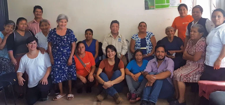 Carolina Noya (arrodillada, tercera desde la izquierda) se une a las pacientes, proveedores y trabajadores comunitarios de salud en la primera cita médica compartida en una clínica comunitaria rural en Soledad, Chiapas.