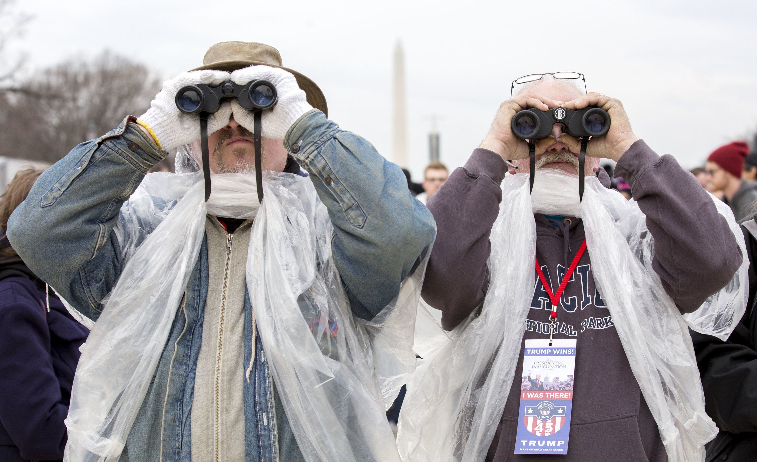Dean Keppler, left, and Mark Koons, of Muncie, IN, use binoculars to get a better view of the capital as Donald Trump is sworn in as the 45th president. Keppler voted for Gary Johnson because he believed he was the better option between Trump and Clinton. Koons voted for Trump and he says he is “cautiously optimistic” that Trump will bring change.