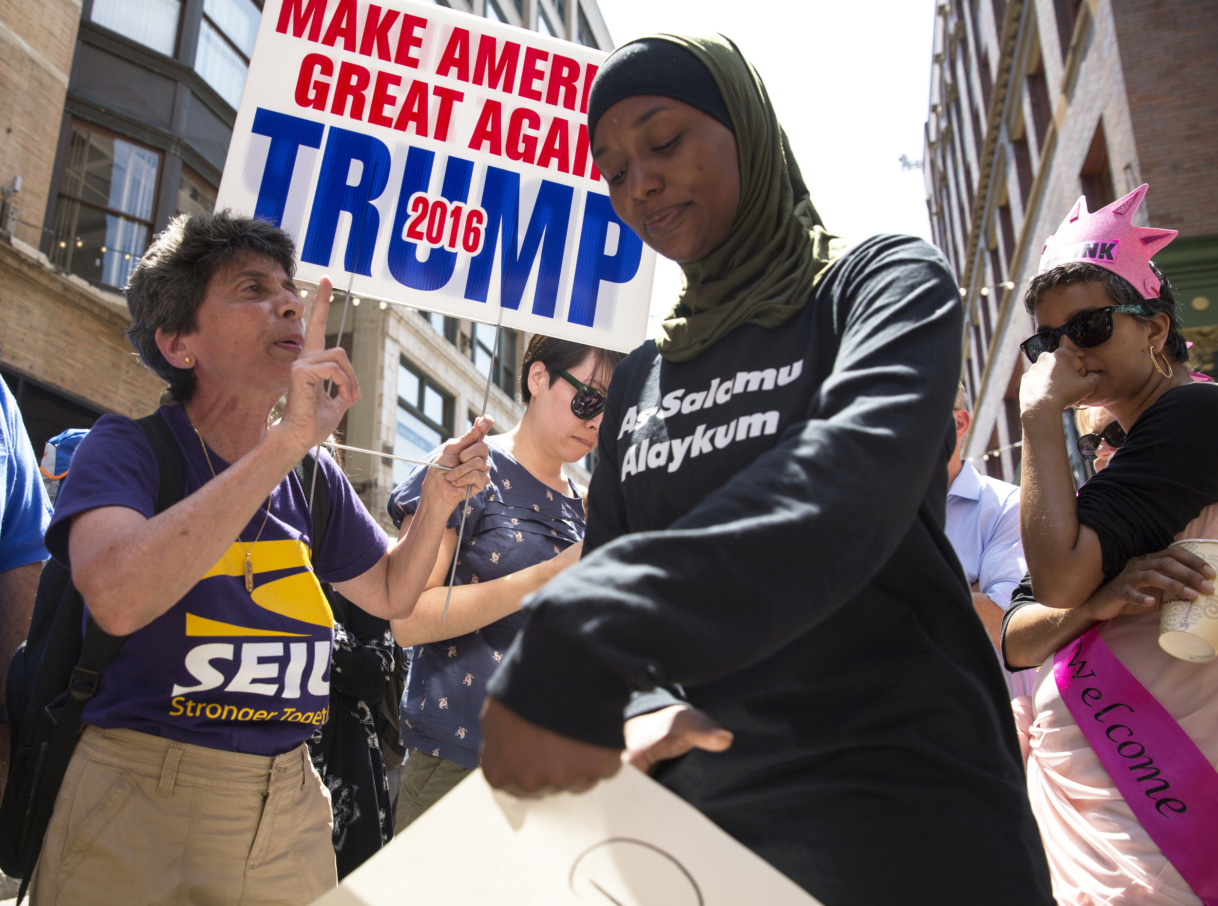  Mariam Noujaim, 62, who is from Egypt, left, tries to make a point about immigration with Desiree Hoy, of Detroit, Mich., on East 4th Street in Cleveland, on the third day of the Republican National Convention on Wednesday, July 20, 2016. Hoy’s shir