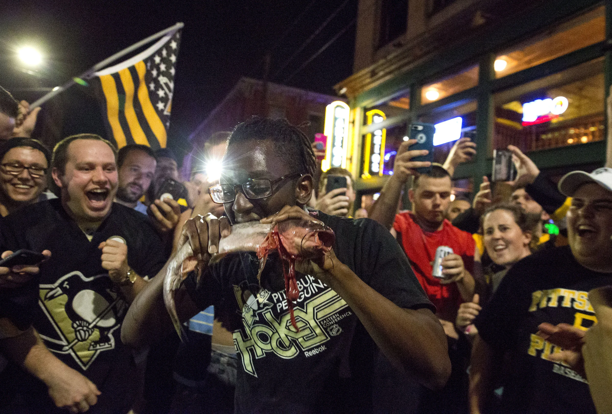 AJ Alleyne, of Philadelphia, eats a catfish as the crowd goes nuts after the Penguins won their second straight Stanley Cup on Sunday, June 11, 2017. The Penguins defeated the Predators 2-0 during game 6 of the Stanley Cup final.