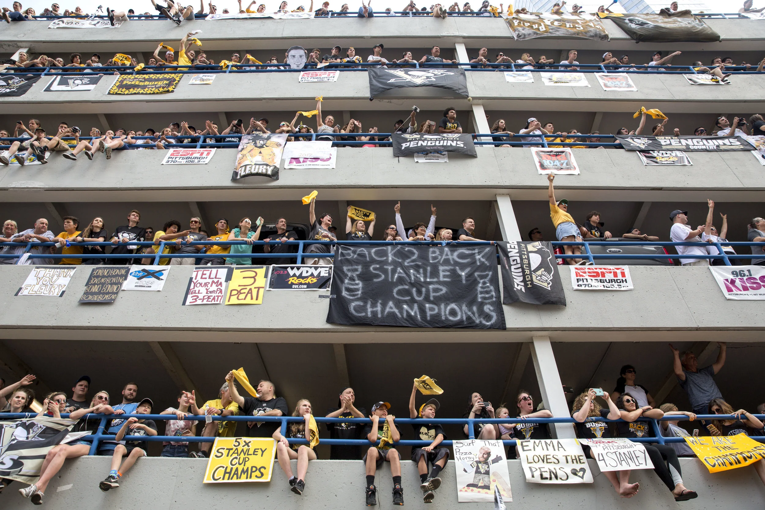 Fans occupy as much space as they can in the Allies Garage in downtown Pittsburgh as they cheer on the Penguins players during the victory parade on Wednesday, June 14, 2017. The Penguins defeated the Predators 2-0 in the Stanley Cup Final during game 6. 