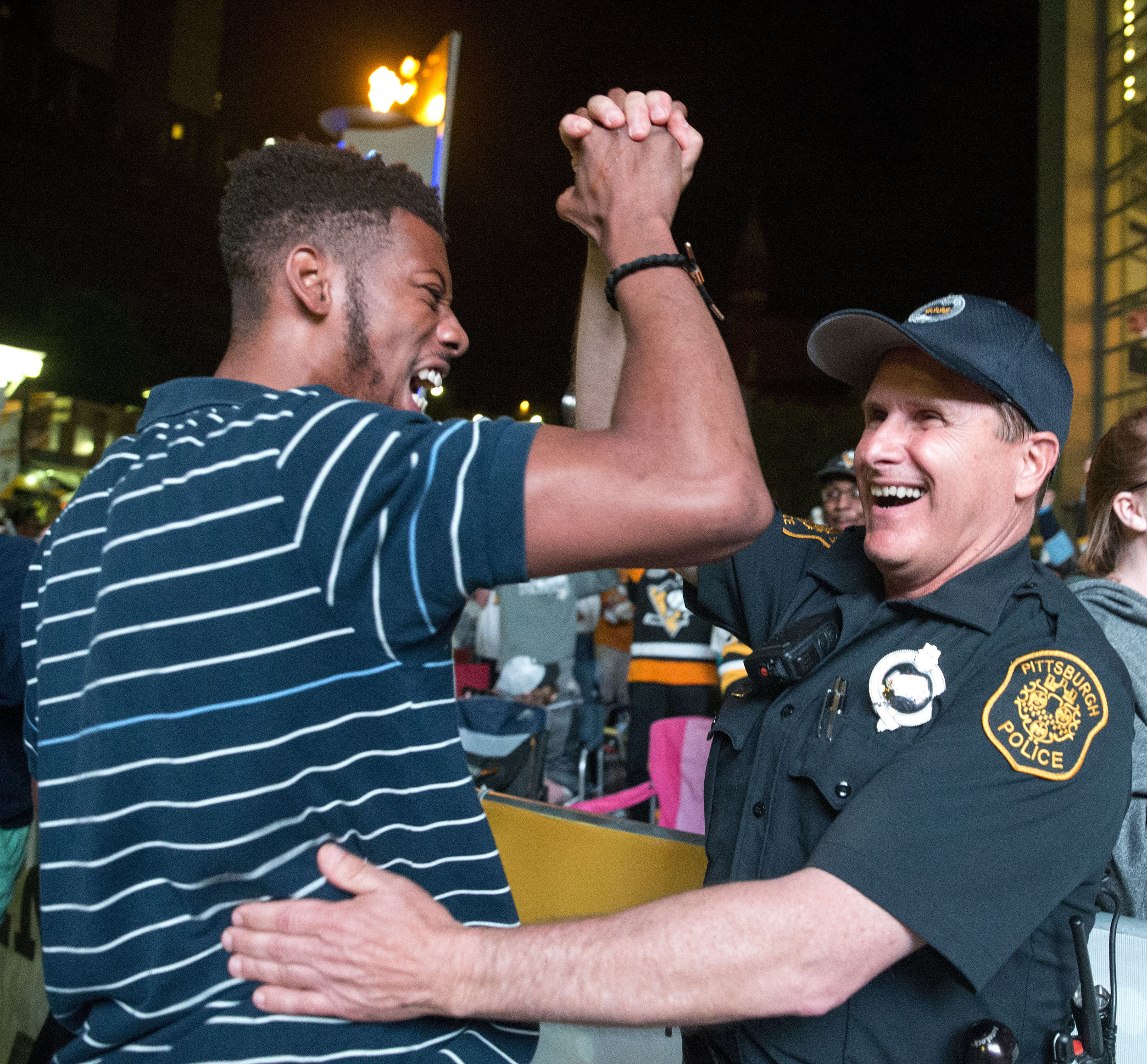  Demtrius Carrington, of Baldwin, celebrates with officer Mike Rosato, of Pittsburgh, after the Penguins scored and lead the game 4-1 against the Predators during Game 2 of the Stanley Cup Finals on Wednesday, May 31, 2017 at PPG Paints Arena.&nbsp; 