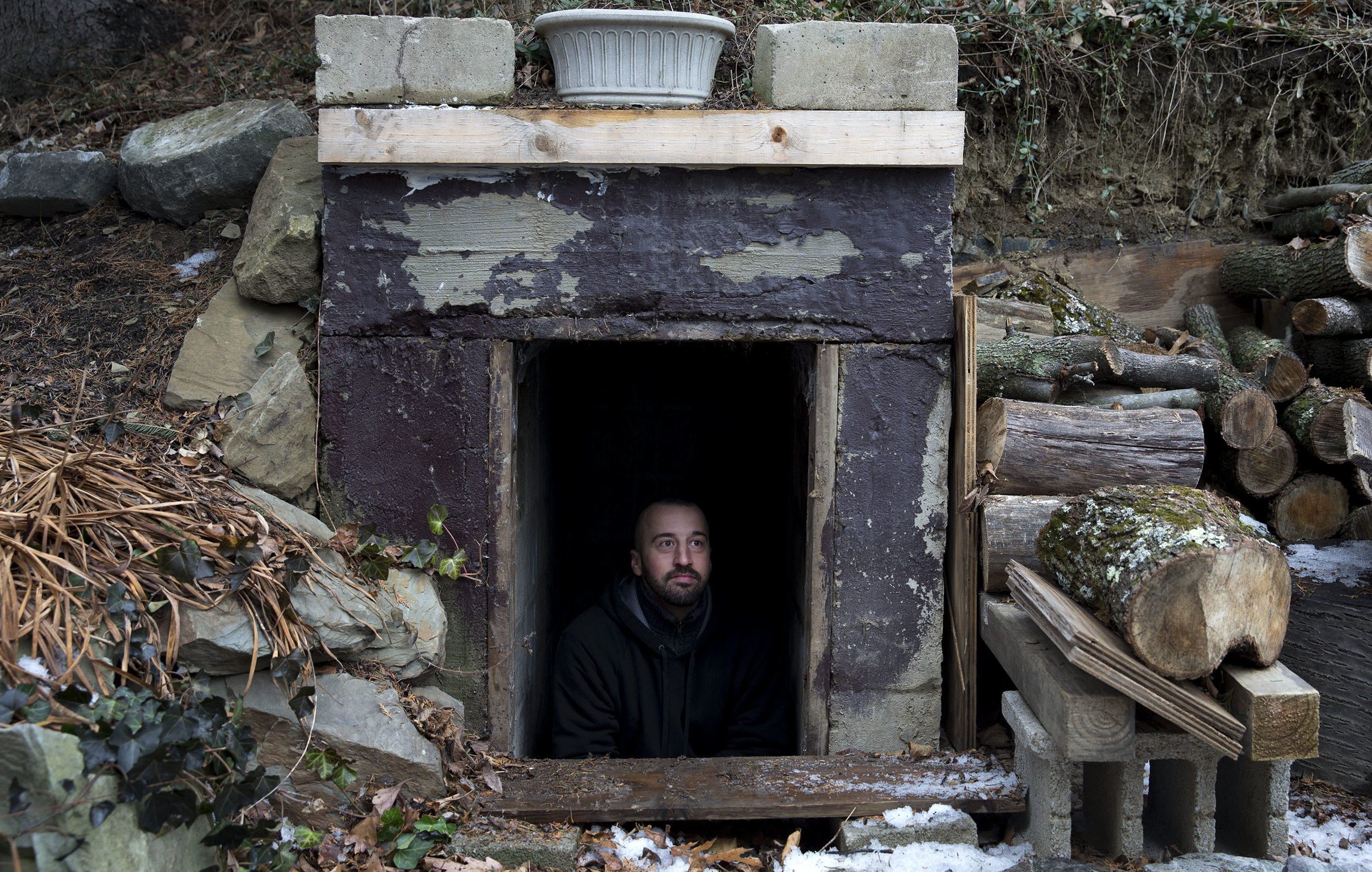 Seth Brokenbek talks with the Post-Gazette while sitting in the entrance of his bunker that was built for shelter into a hillside on his property on Wednesday, Jan. 10, 2018 in Murrysville. 