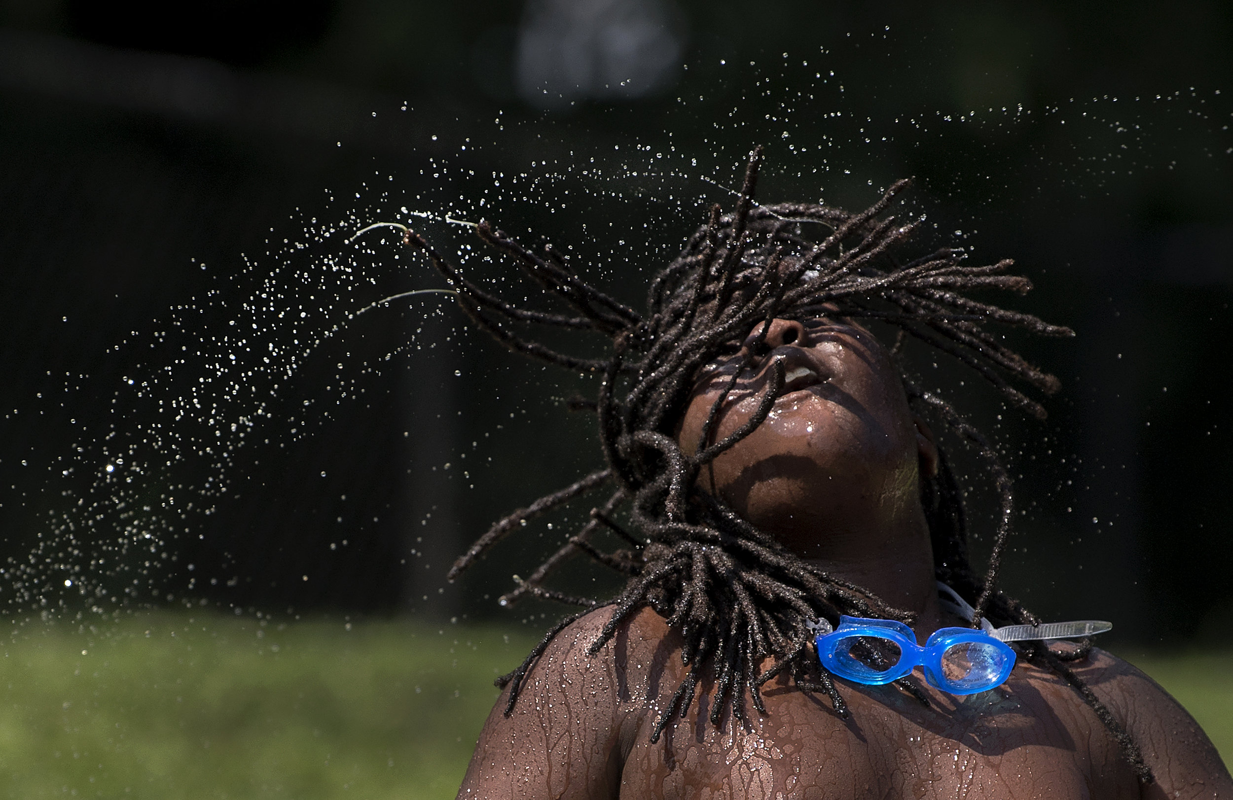  Marious Chaney, 11, of North Side, flips his hair back and forth during a hot afternoon on Sunday, July 1, 2018 at the Troy Hill Spray Park.  