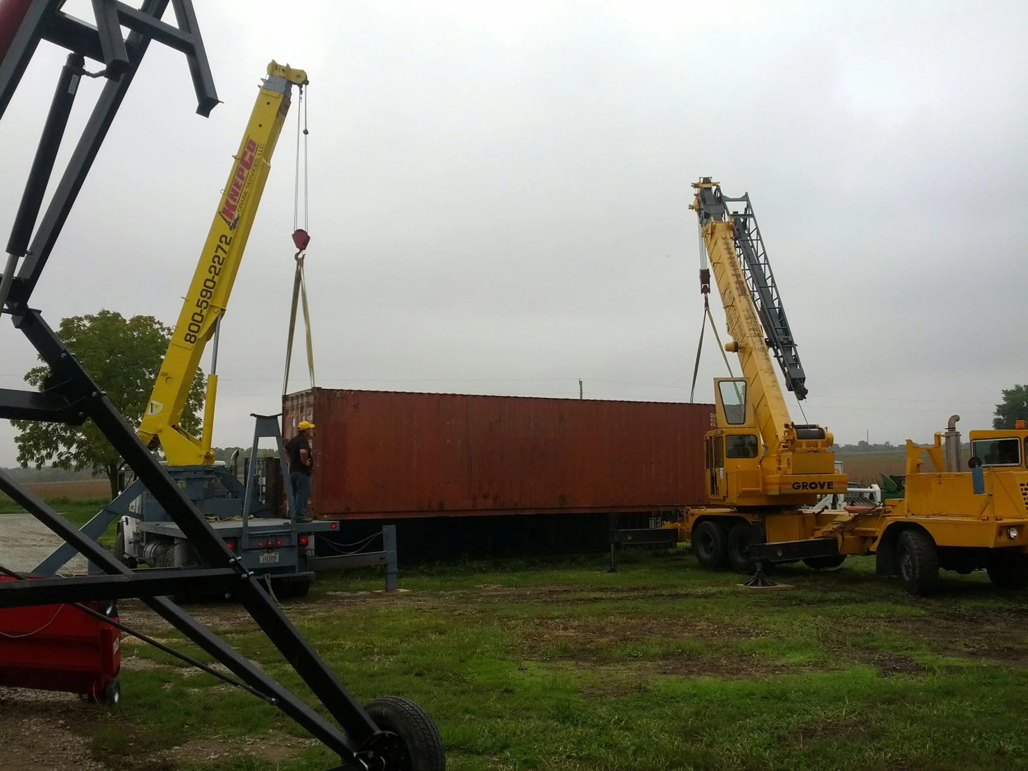 KnepCo Crane Services using two cranes to  move a large metal container in Columbus, IN.