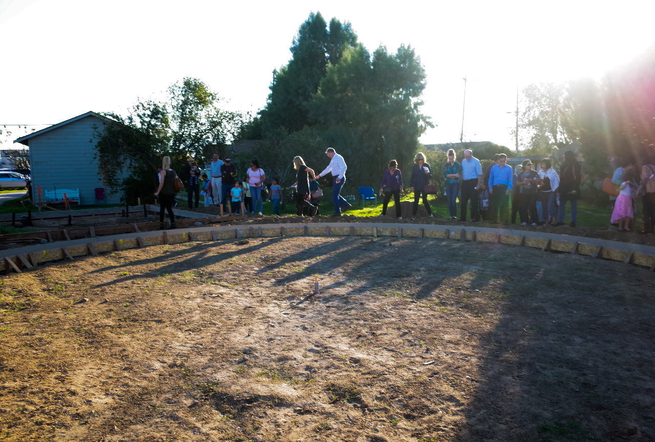Members of the community gathered around the round foundations.