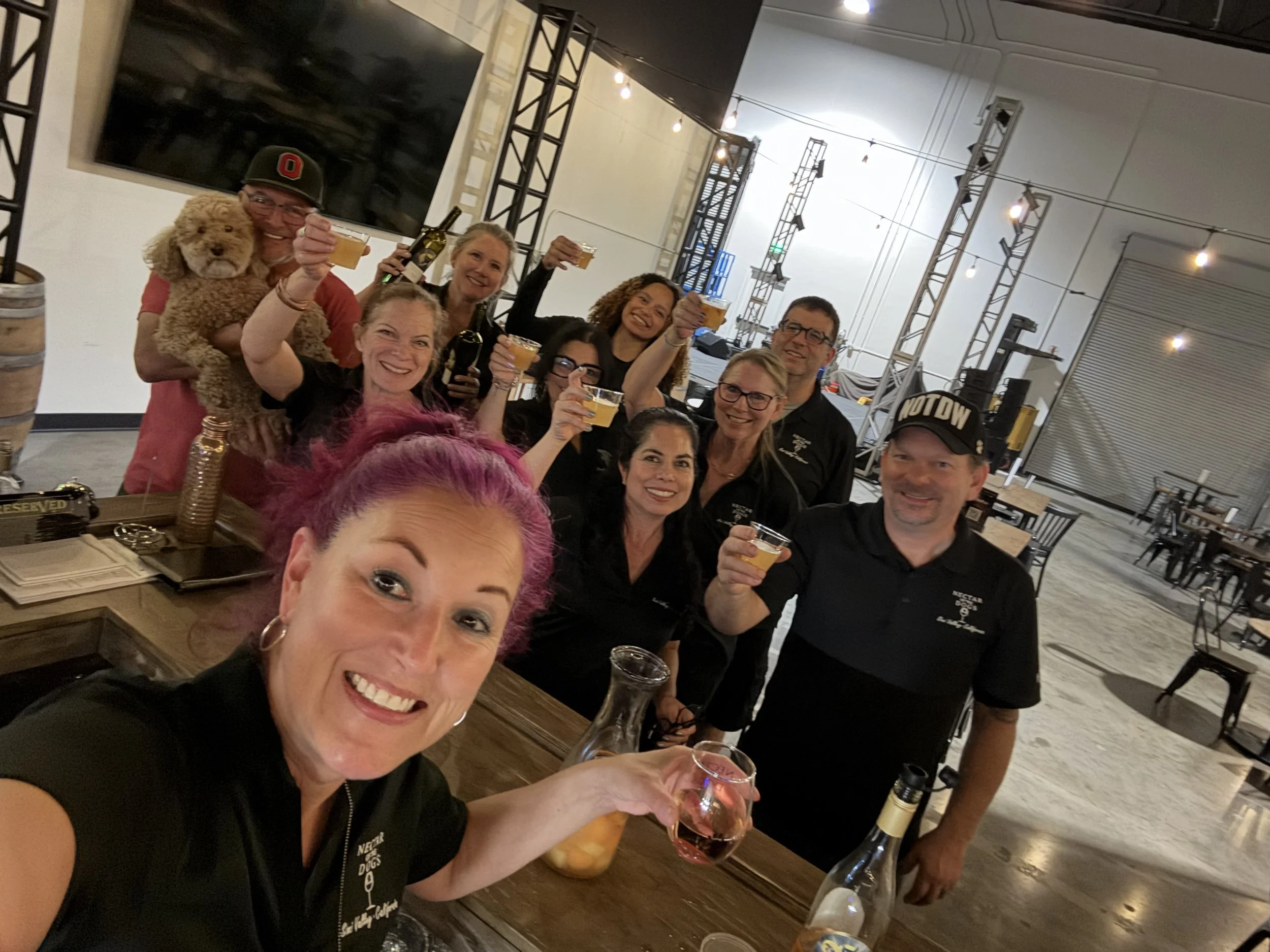 The NOTDW staff holding up their wine glasses in the tasting room.