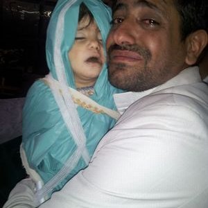 Ibrahim Abdulkareem holding his one year old daughter, Zainab, for the last time before her burial.