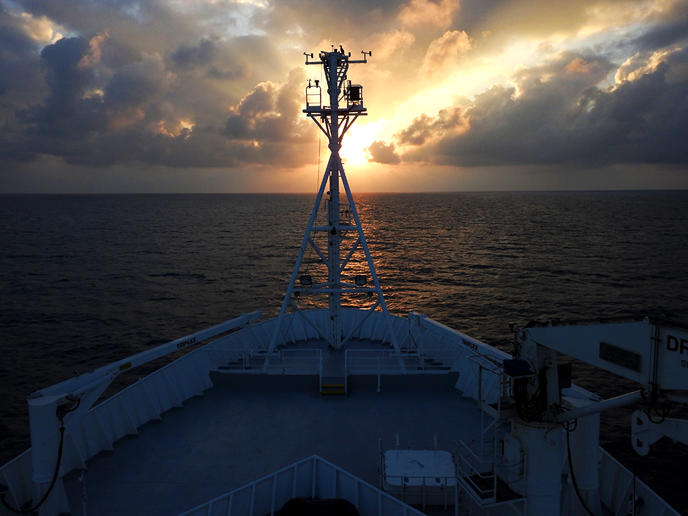 The Sun sets on our voyage. Note the majestic lone booby atop the mast. Photo: Katie Walters
