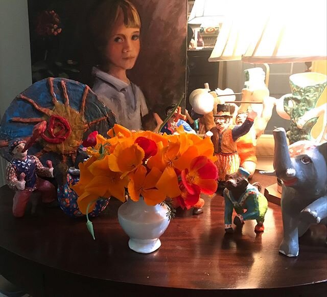 Picked this morning, these California poppies have given me such a boost in this strange time. The portrait is of my boy, the pottery on the left, his creation, and the paper Mache circus painted by me.