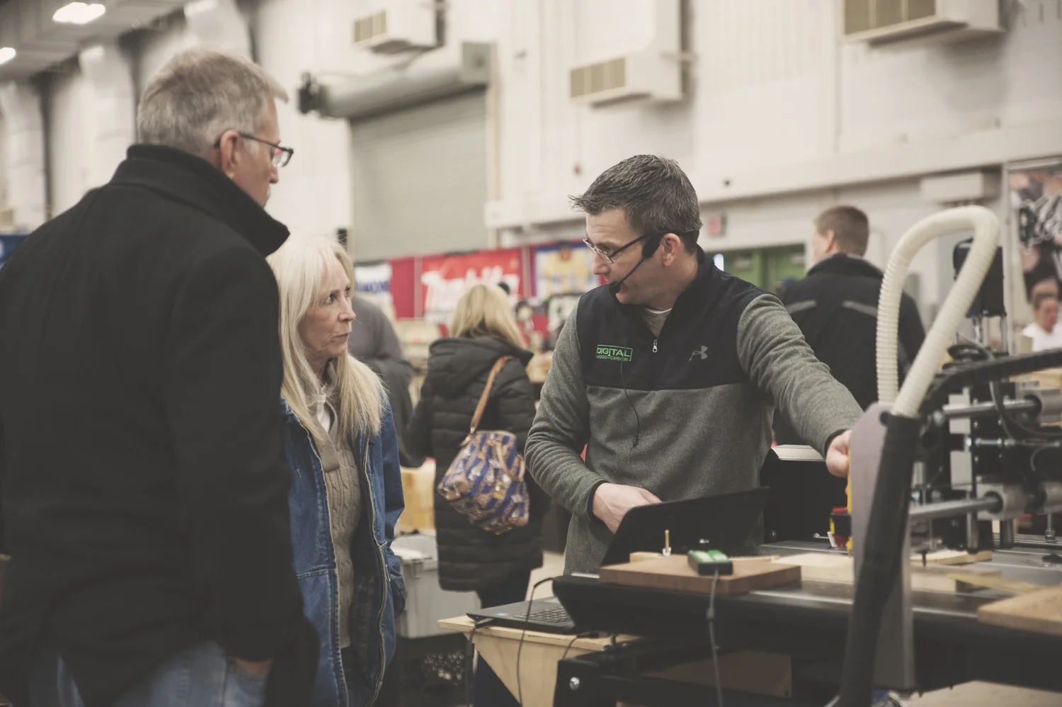 Digital Wood Carver team member walking visitors through a CNC demo