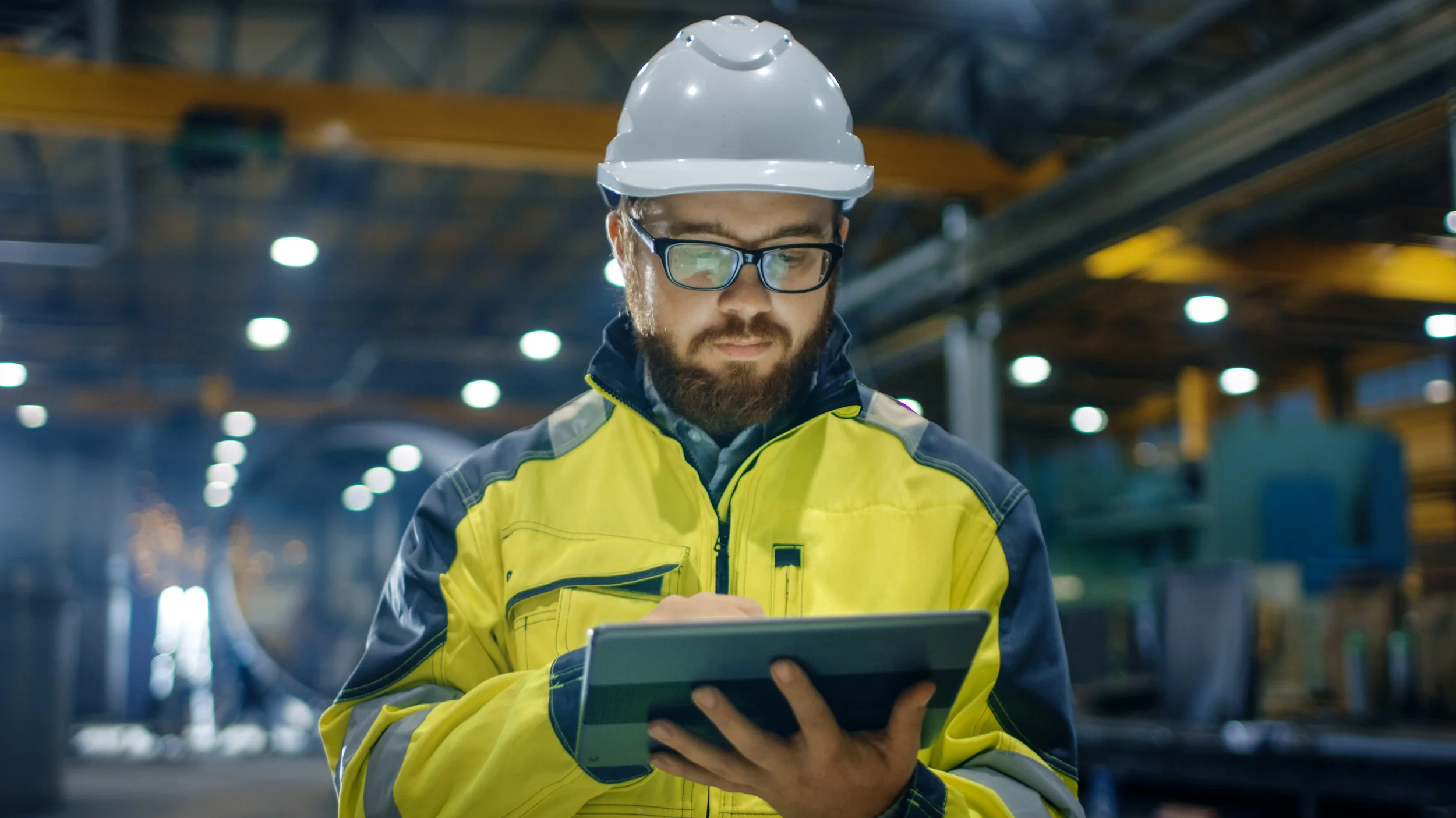 Man wearing hardhat uses construction mobile form on tablet