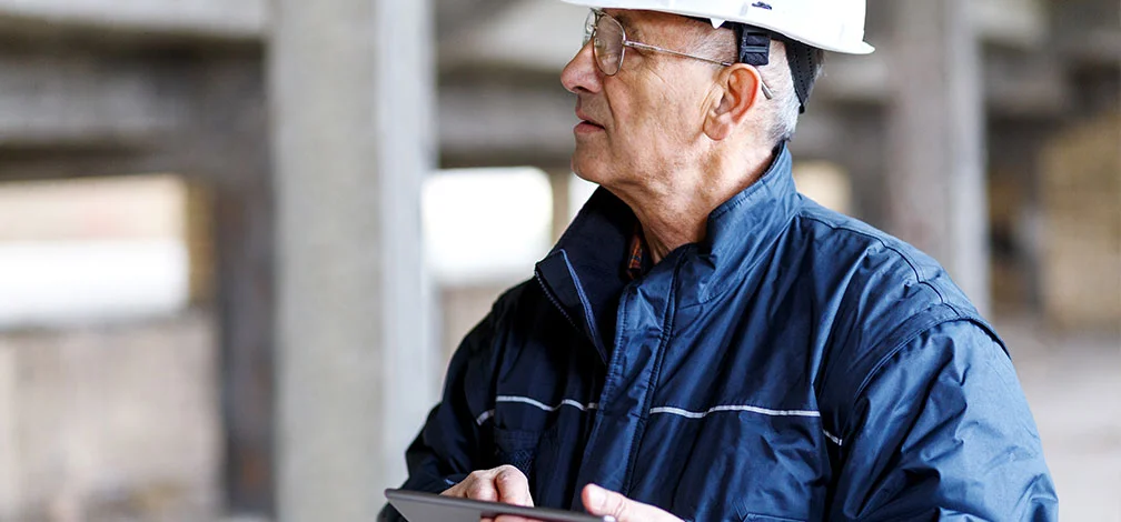 Oldcastle engineer inspects quality control process with white hard hat and ipad