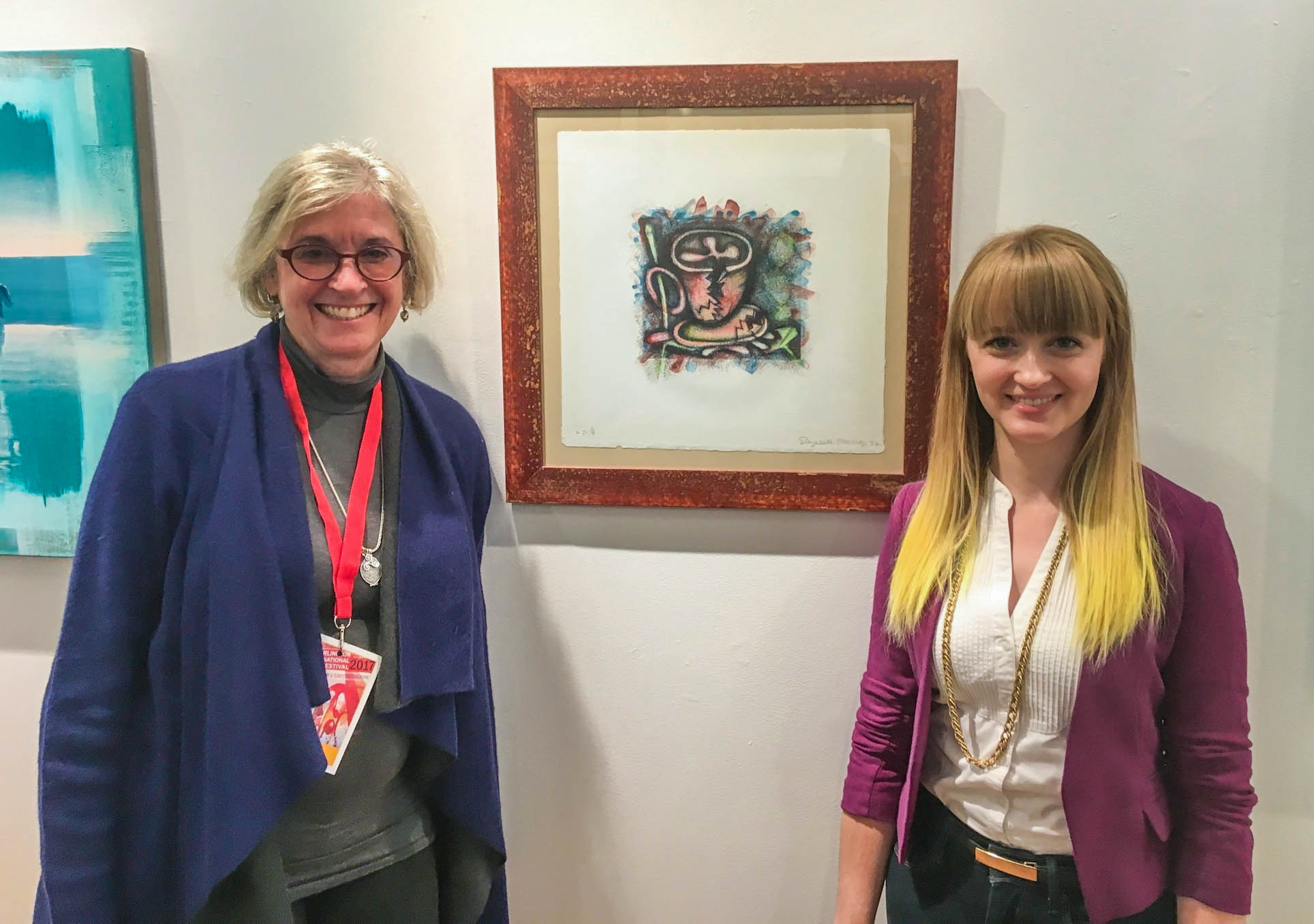 Caitee Hoglund and Kristi Zea next to a print that Elizabeth Murray gifted to Zea for her birthday.
