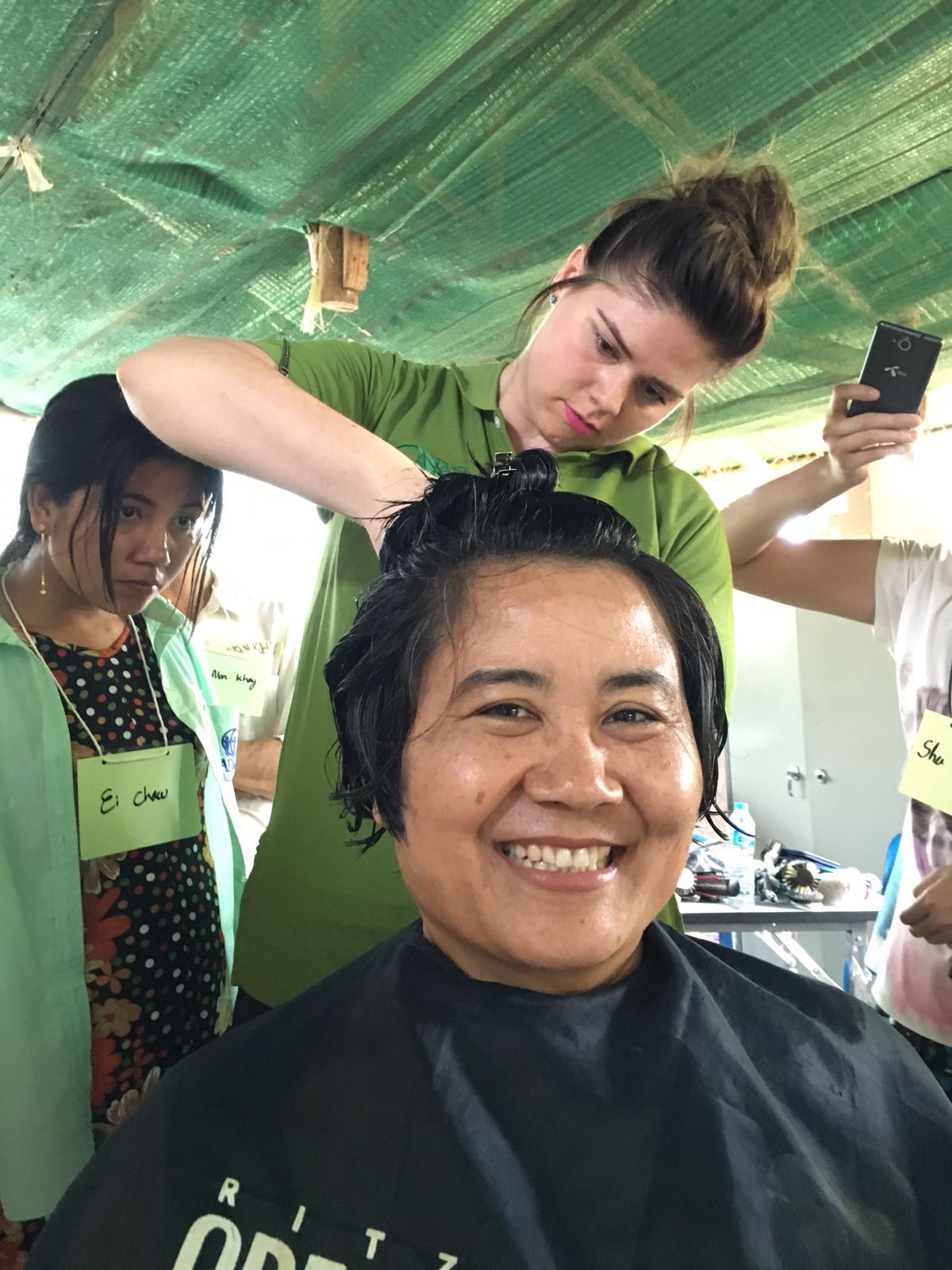 Natalie Hansen from HAUS Salon demonstrates hair cutting techniques on Dina, GBV Manager for Nu Po.