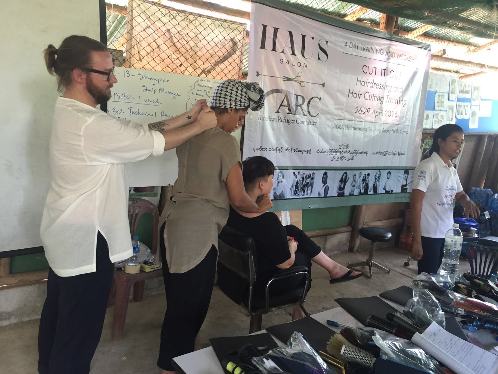 Charlie, Nikki and Reilly teach the pre-haircut massage technique as Kay Thi translates for the class.