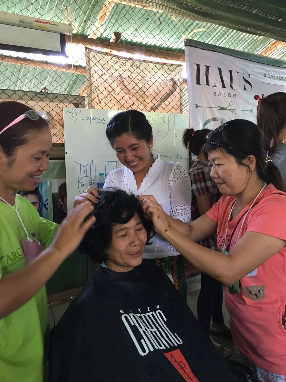 Students practice a twisting technique to style curls.