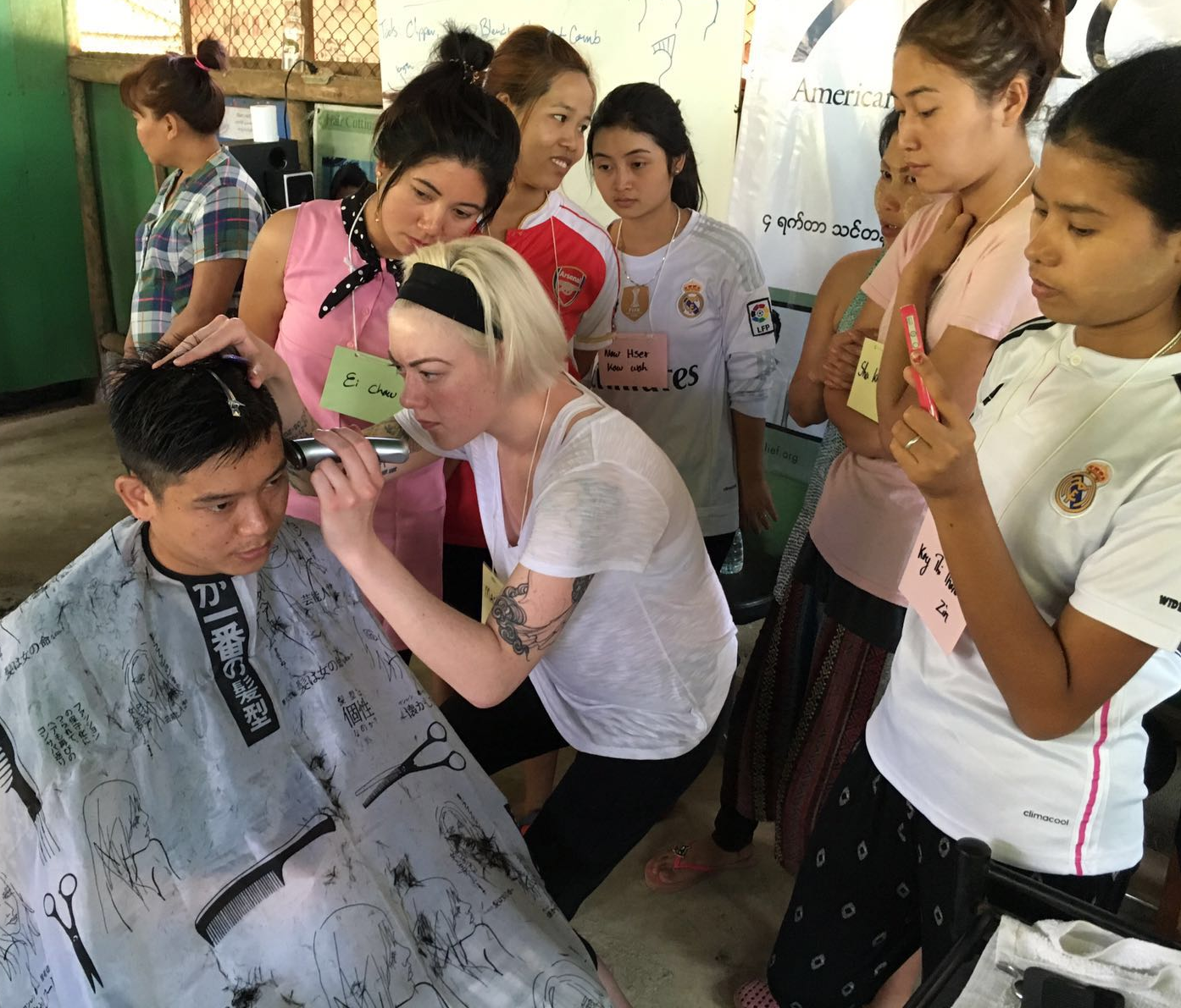 Mackenzie demonstrates a fade during a men's haircut.