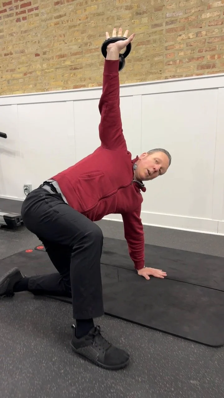 Dr. Adam Bruene demonstrating a loaded movement exercise with a kettlebell