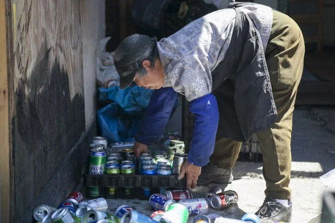   Yabi Luo, an immigrant who collects cans from trash receptacles for a living, sorts her cans at the Sure We Can redemption center in Bushwick, Brooklyn. (Samira Bouaou/Epoch Times)  