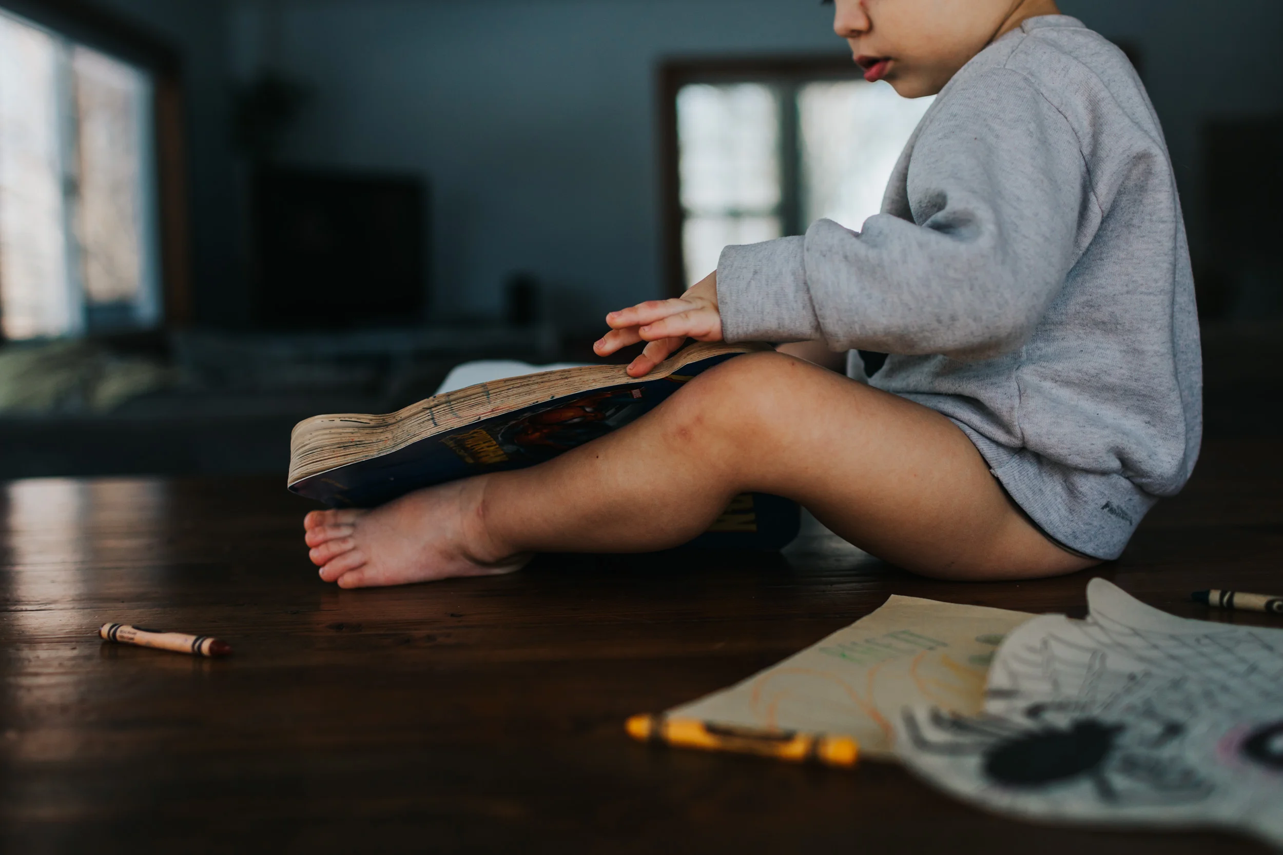 young boy coloring on top of table at home