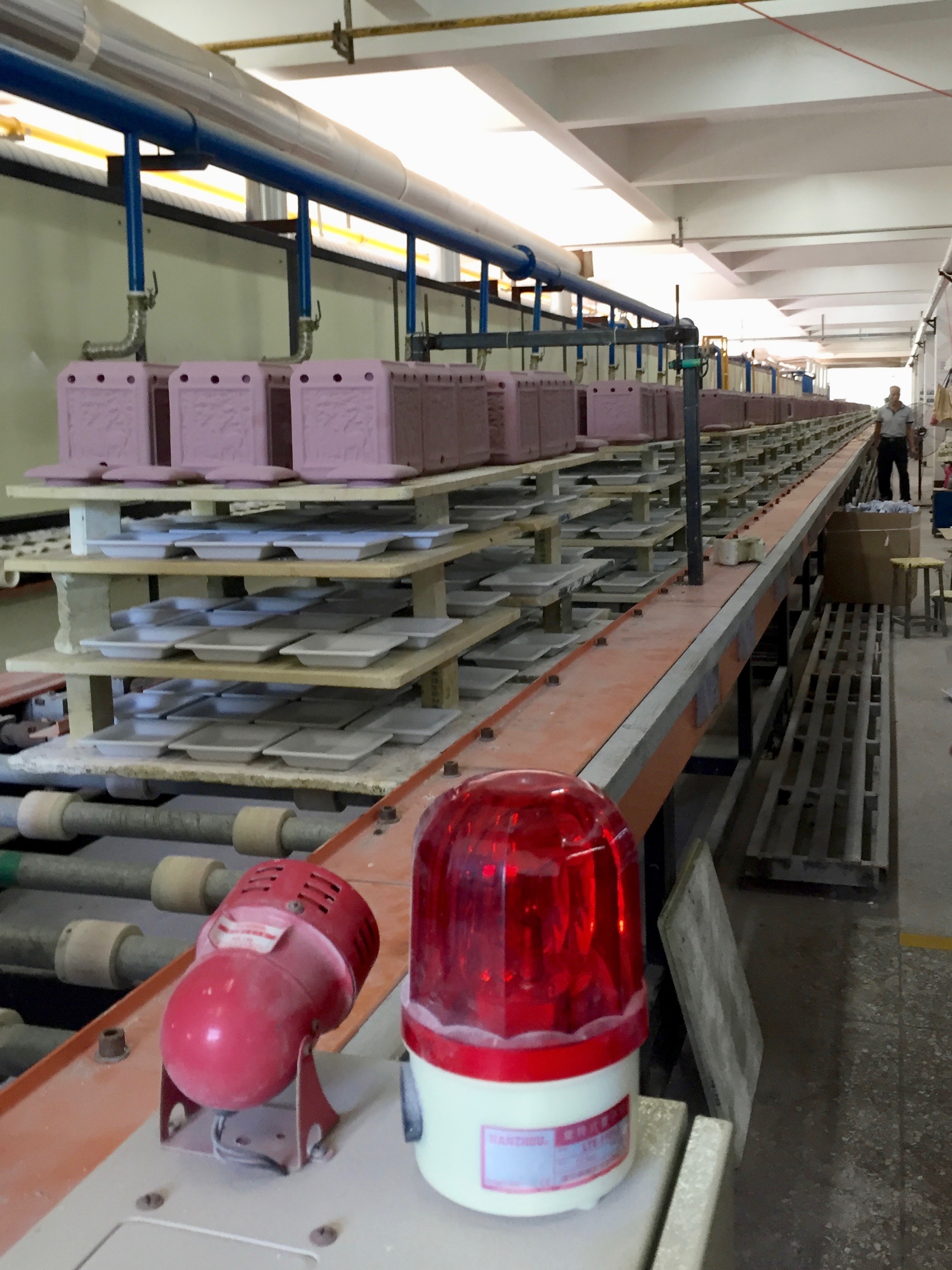  This is a computerized kiln that is continuously moving. &nbsp;It takes about 8 hours for one piece to move through the entire kiln. &nbsp;What you see here is a long conveyer belt where ceramic items are stacked onto the shelves. &nbsp;The shelves 